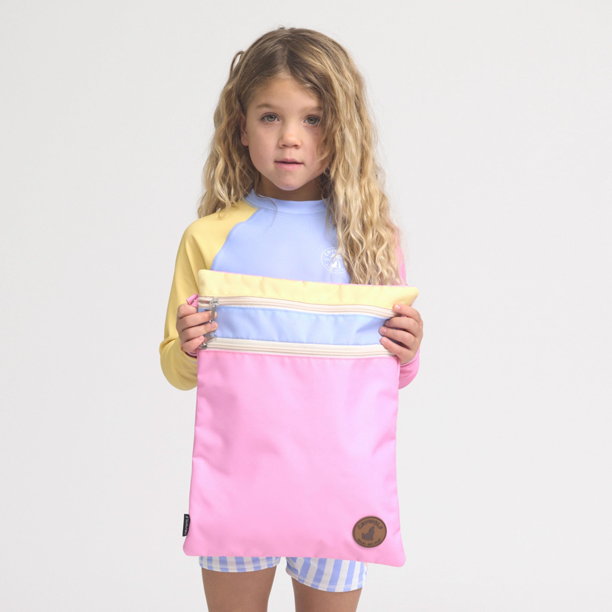 Girl holding a multicolored swim bag.