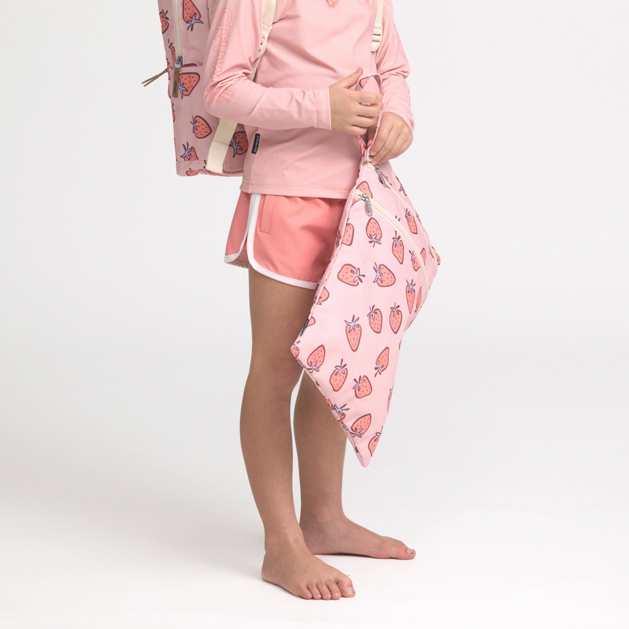 Girl holding a multicolored swim bag.