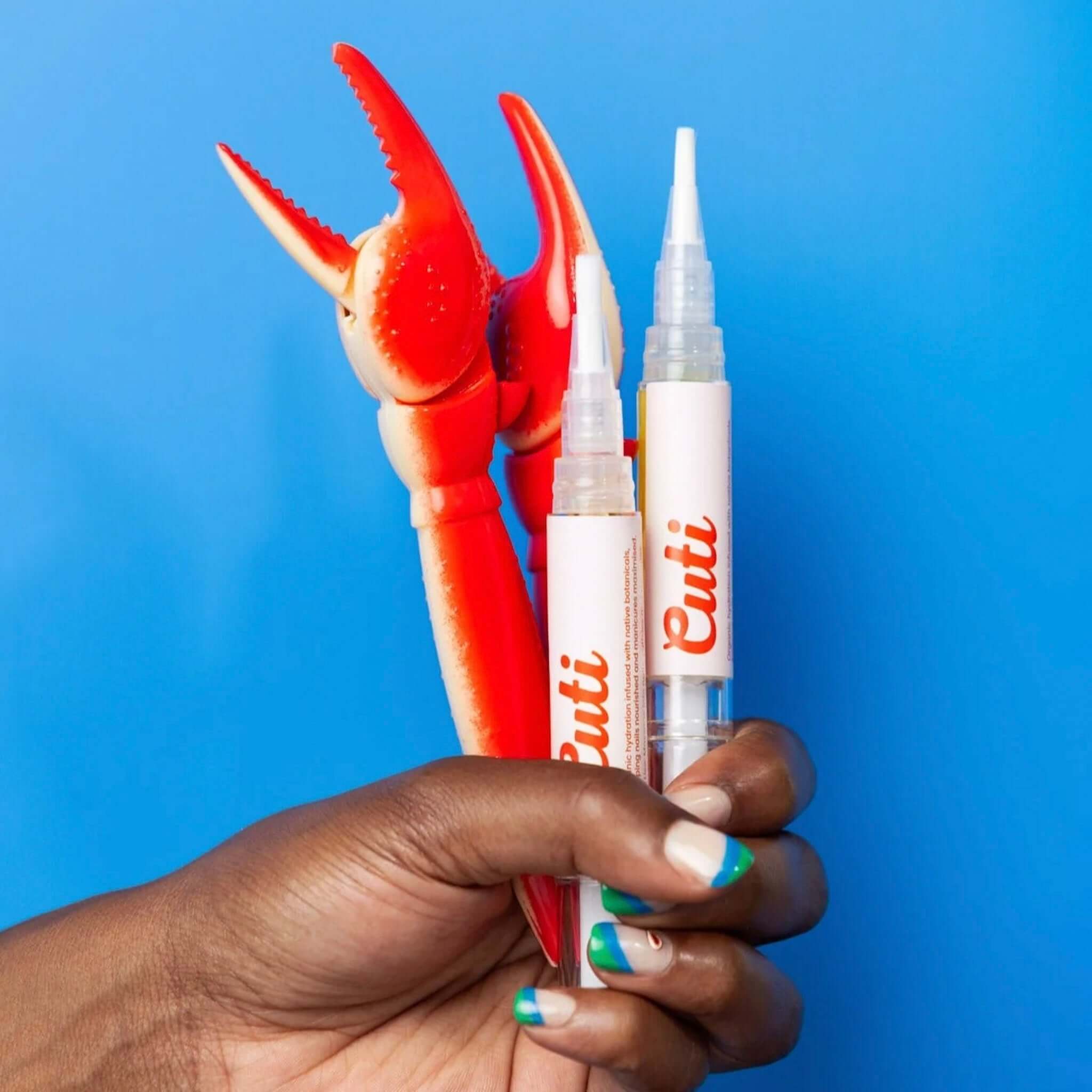 Alt Tag: Cuti Fresh Cuticle Oil Pen - Original refillable cuticle oil pens held in hand with manicure, eco-friendly nail care