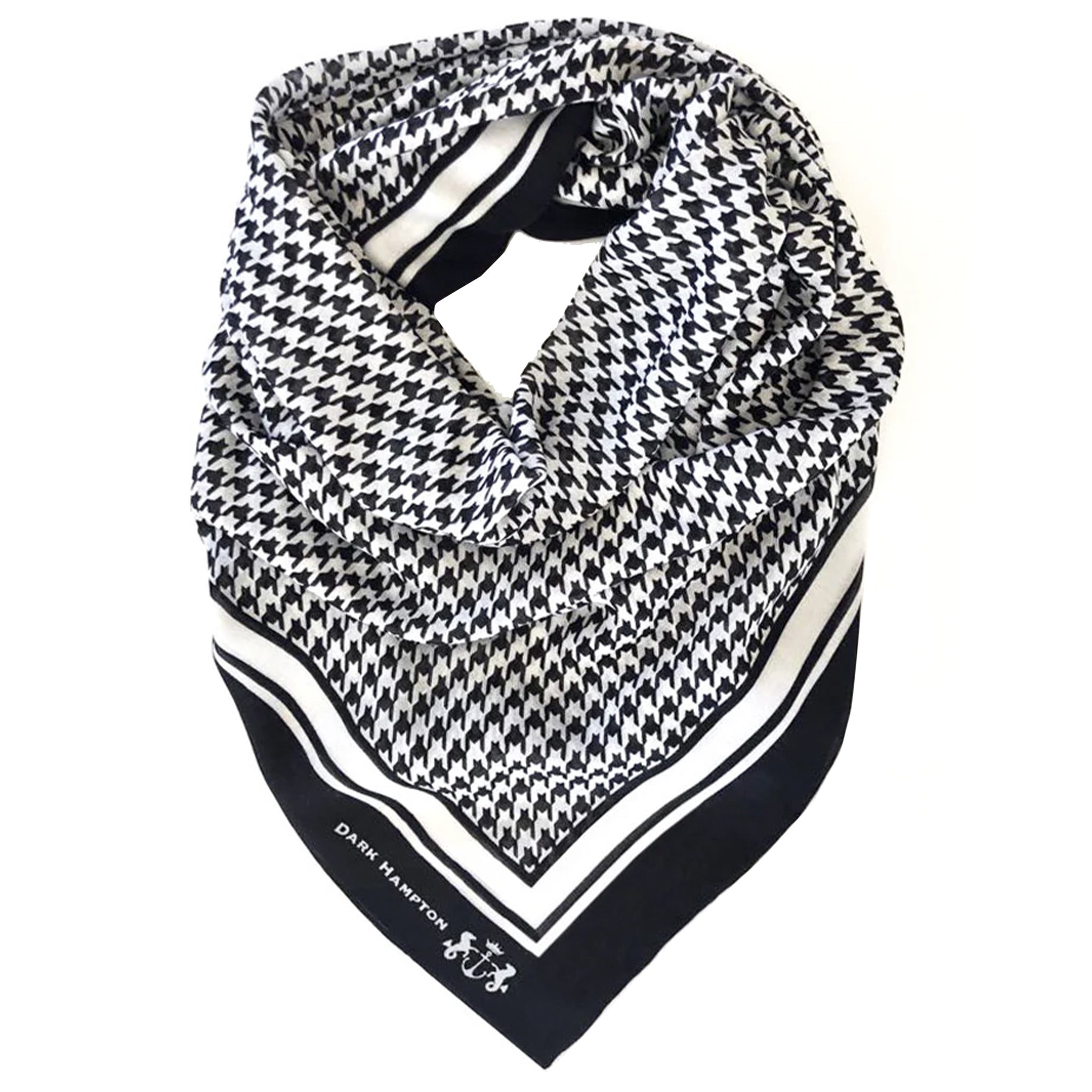 Black and white houndstooth patterned scarf with a brand logo on a white background