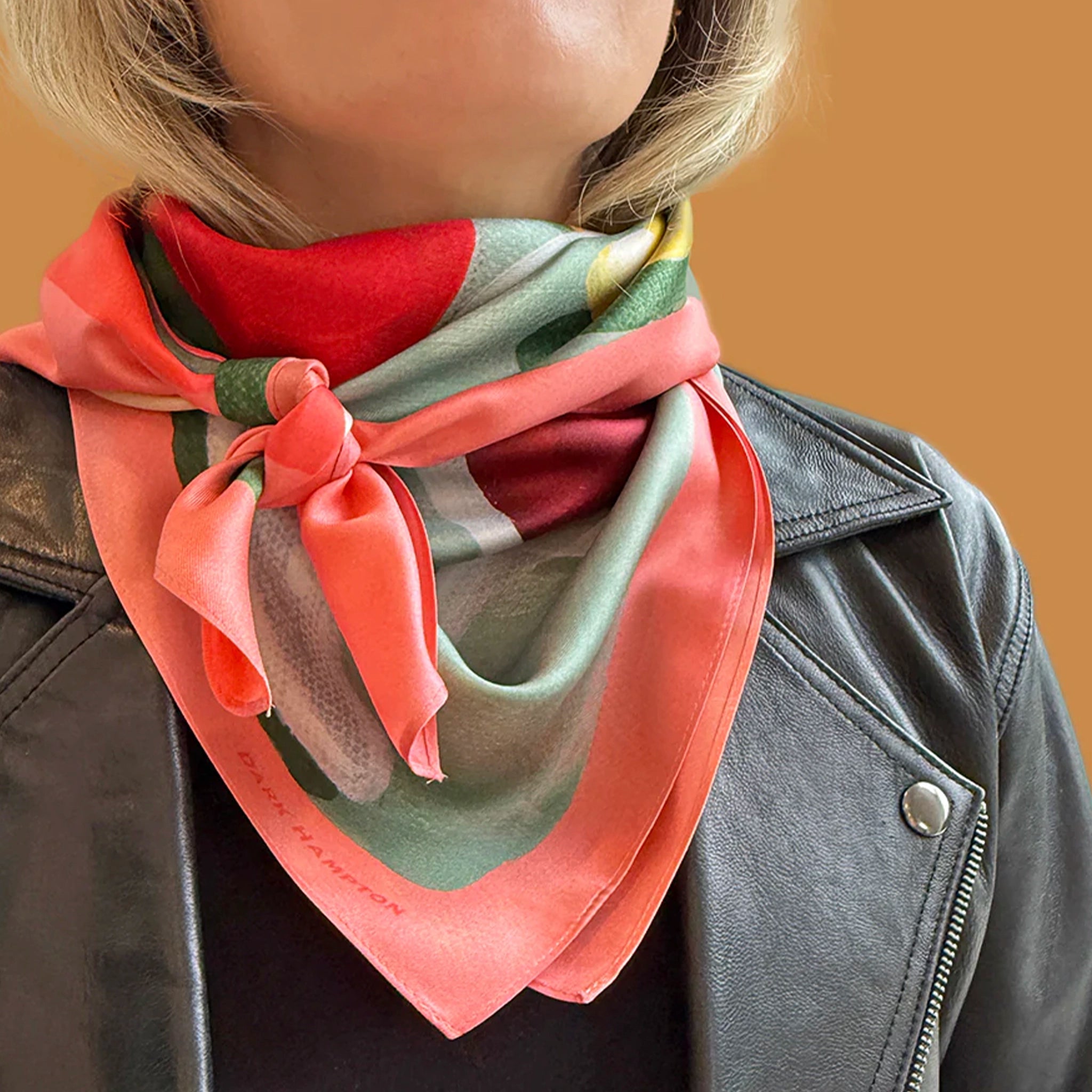 Person wearing a colorful scarf with a brown background