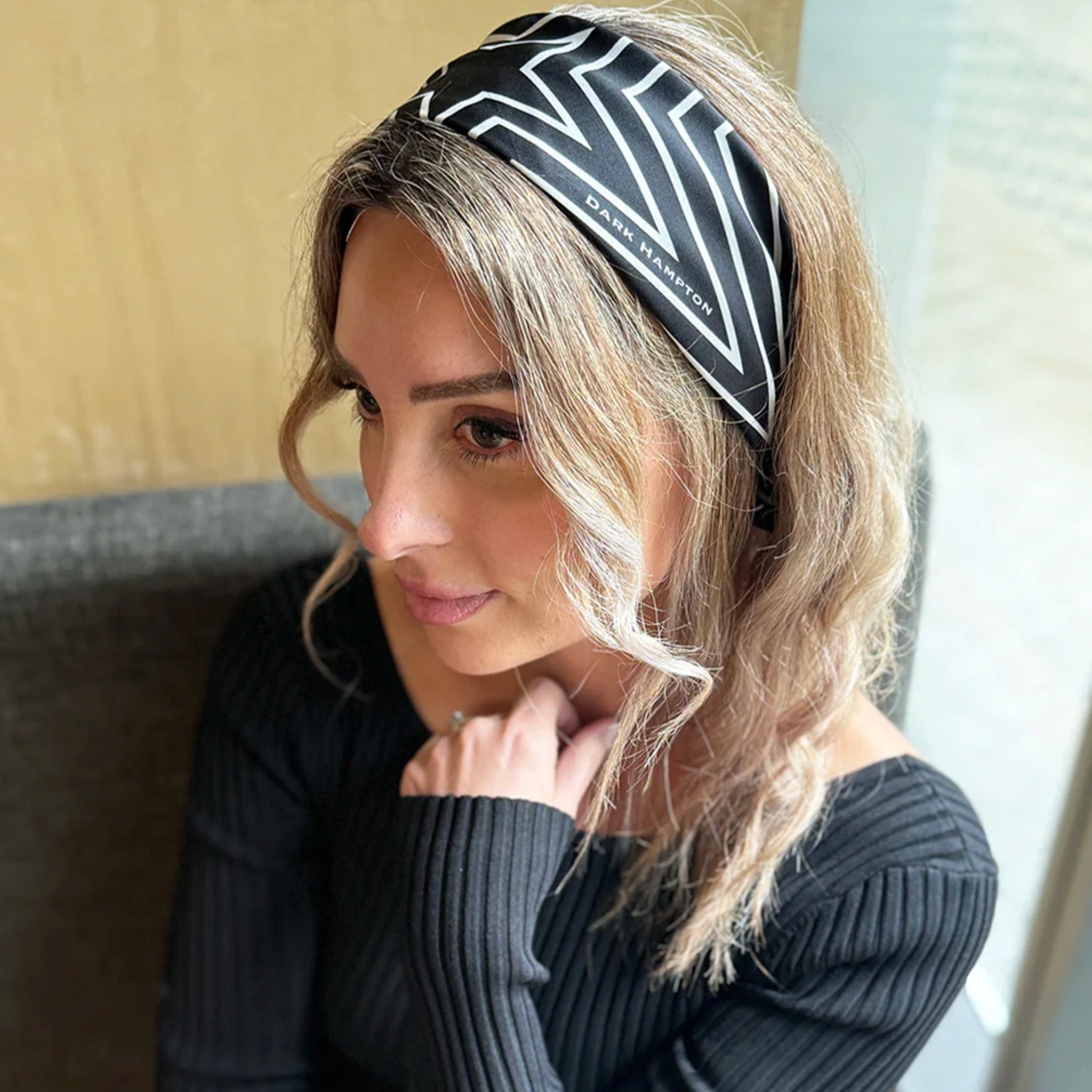Woman wearing a black and white patterned headband indoors