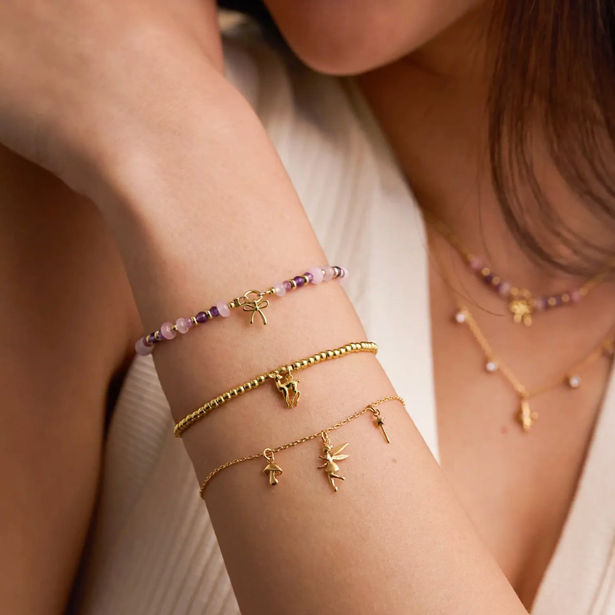 Estella Bartlett Bambi Deer Sienna Bracelet worn on the wrist, stacked with beaded bracelets