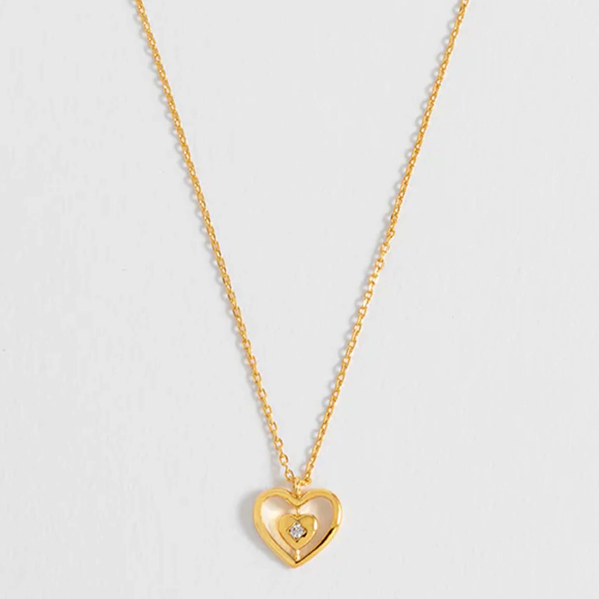 Alt Tag: Estella Bartlett Enveloped Heart CZ Necklace - Gold Plated gold chain necklace with layered heart pendant and sparkling cubic zirconia