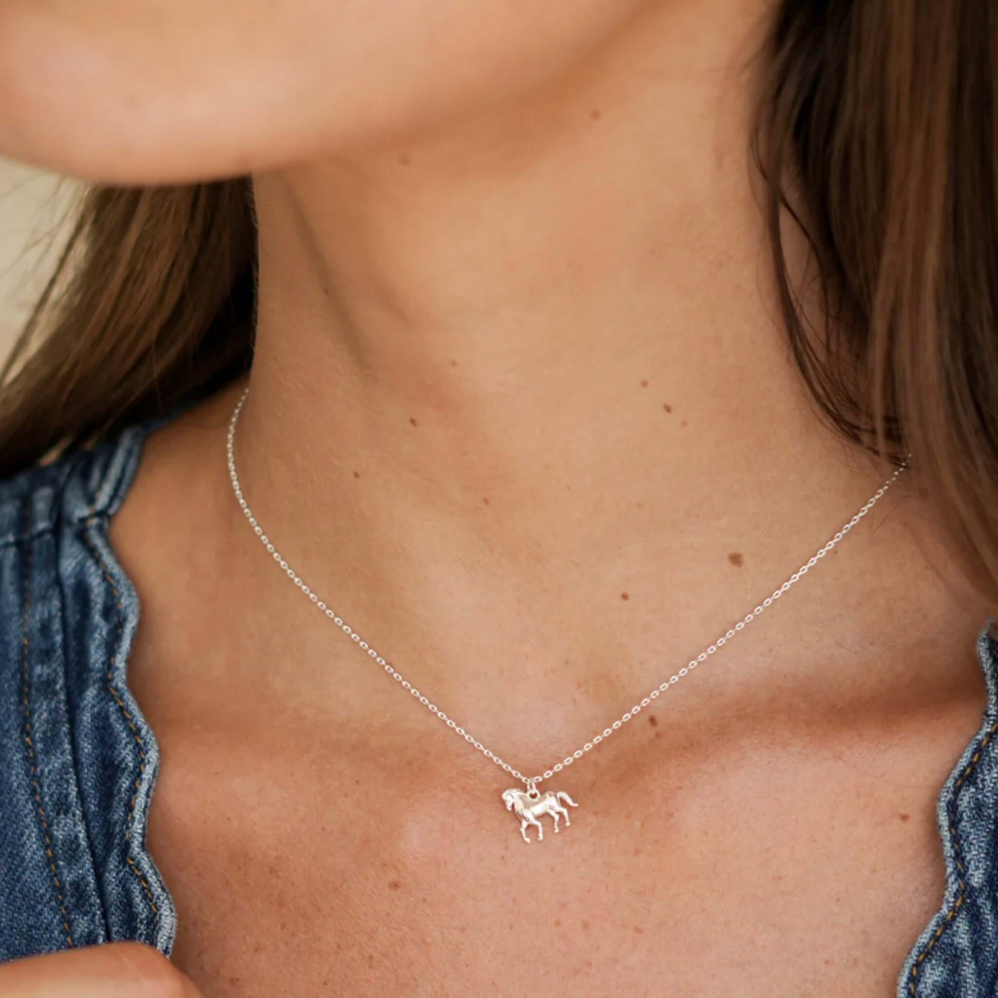 Alt Tag: Estella Bartlett Horse Necklace - Silver sterling silver trotting horse pendant necklace on delicate chain, worn layered daily