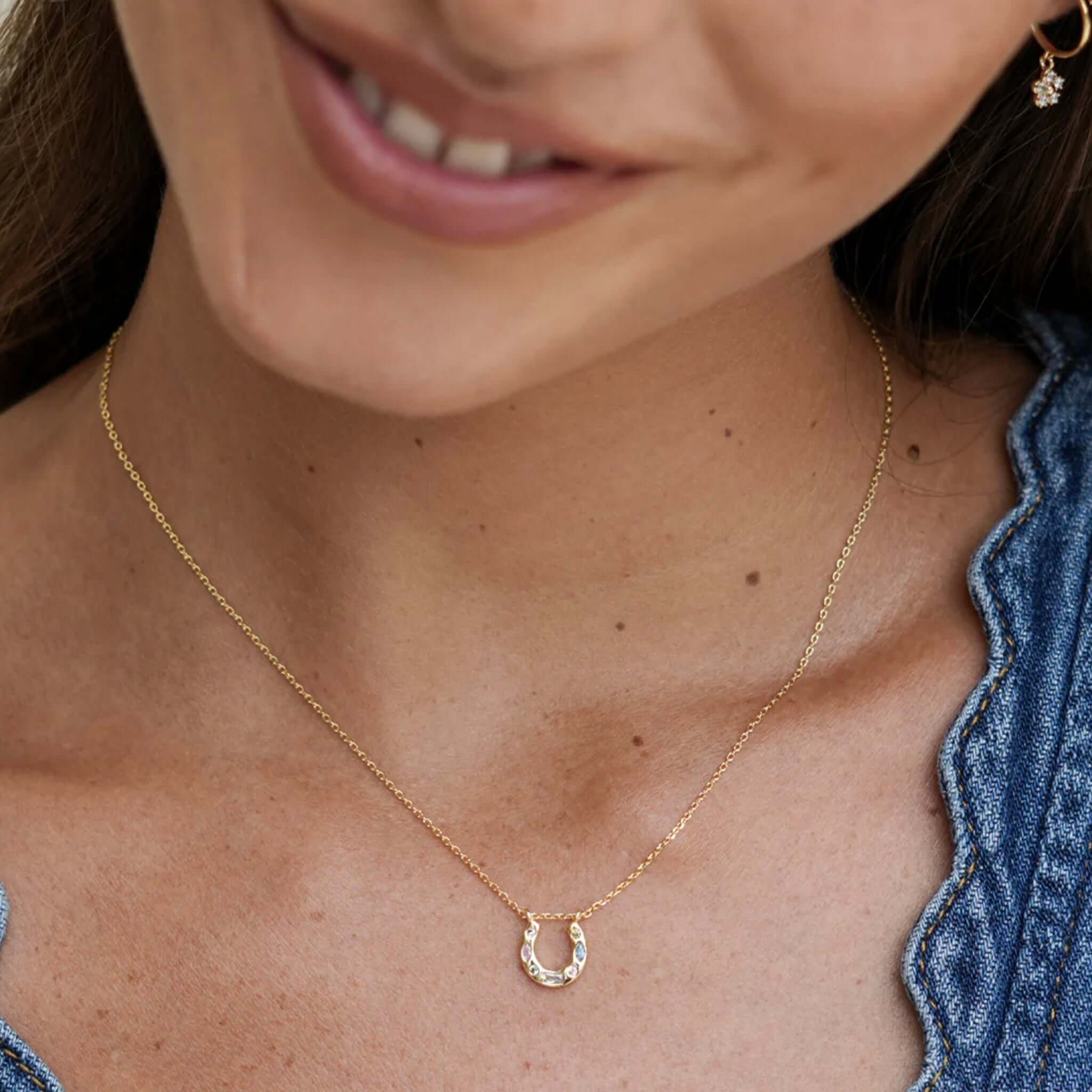 Alt Tag: Estella Bartlett Horse Shoe Multi Pastel CZ Necklace - Gold Plated worn on model, gold horseshoe pendant with pastel CZ stones