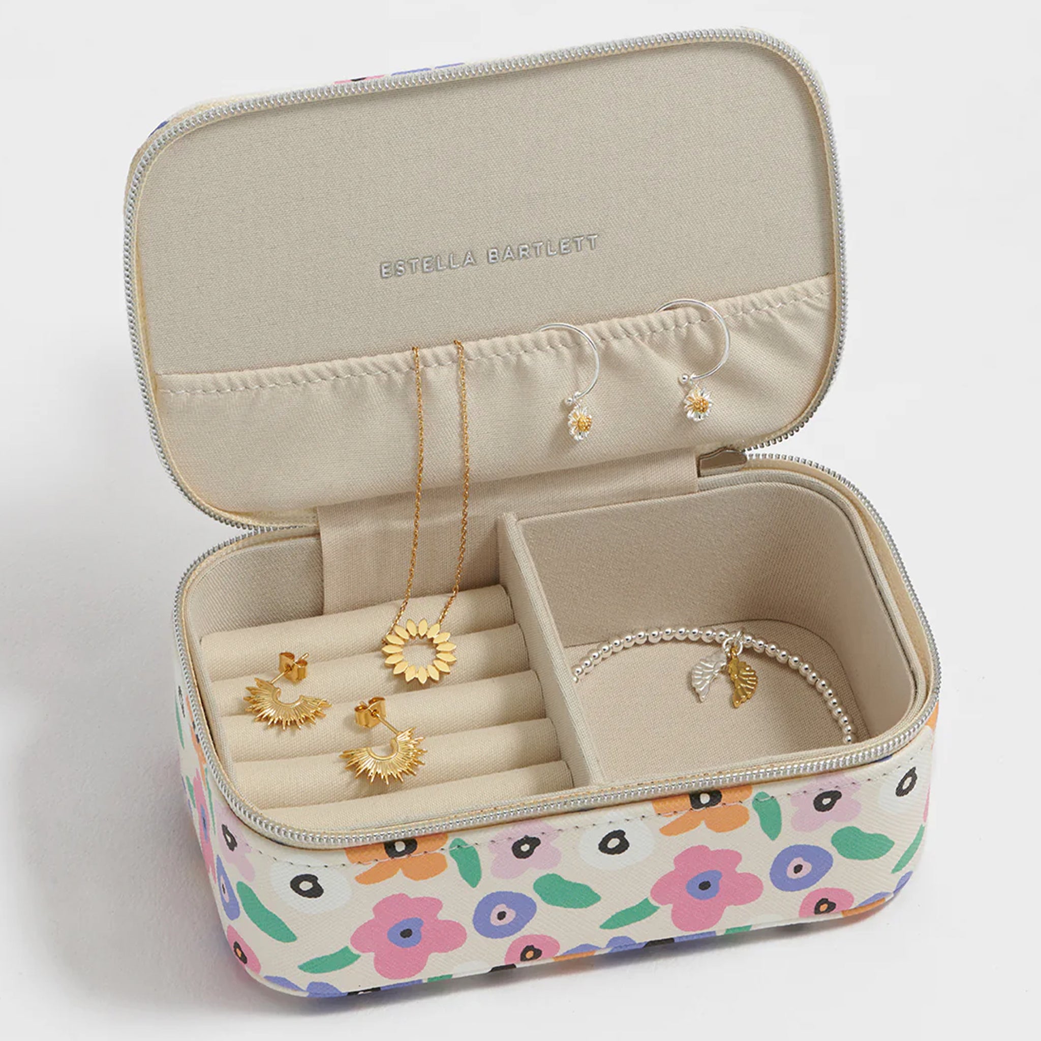 Jewelry box with floral design containing jewelry on a white background