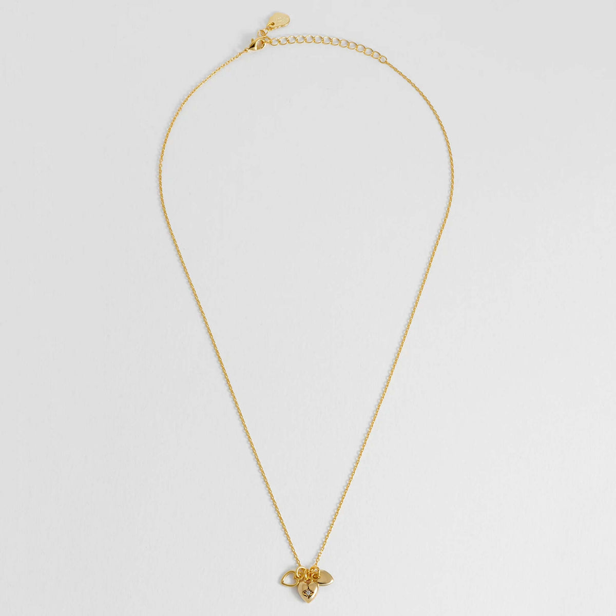 Estella Bartlett Triple Heart Charm Necklace featuring three heart charms on a delicate gold-plated chain.
