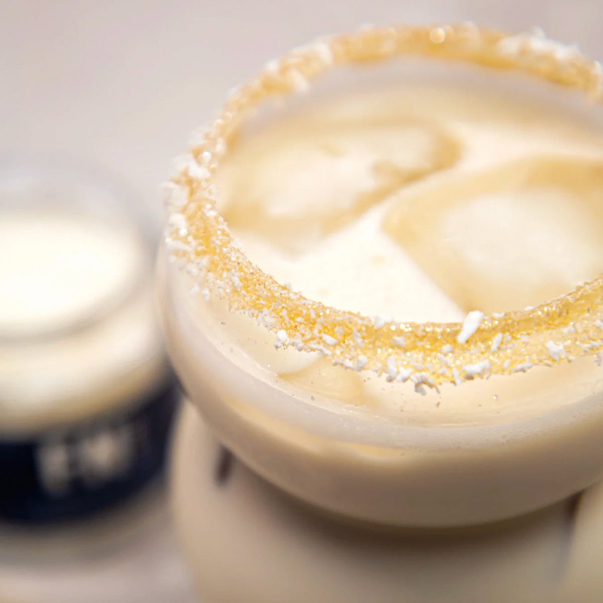 F N Lemons Rim Dust - Pineapple Coconut, close-up of glitter sugar rim on a creamy iced cocktail