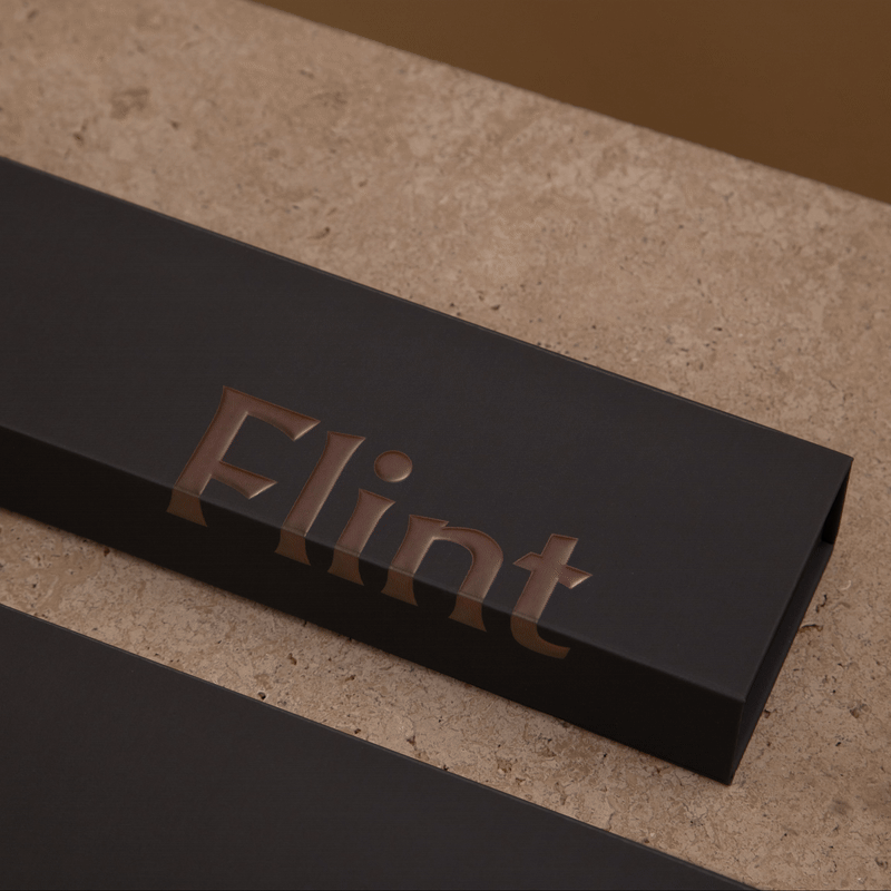 Tall, thin gunmetal metallic lighter in a box