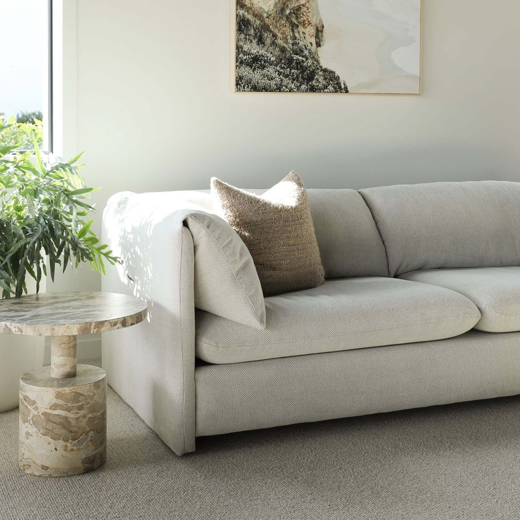 Freddie 3 Seater Sofa in light beige fabric with fold-over arm cushion in sunlit modern living room