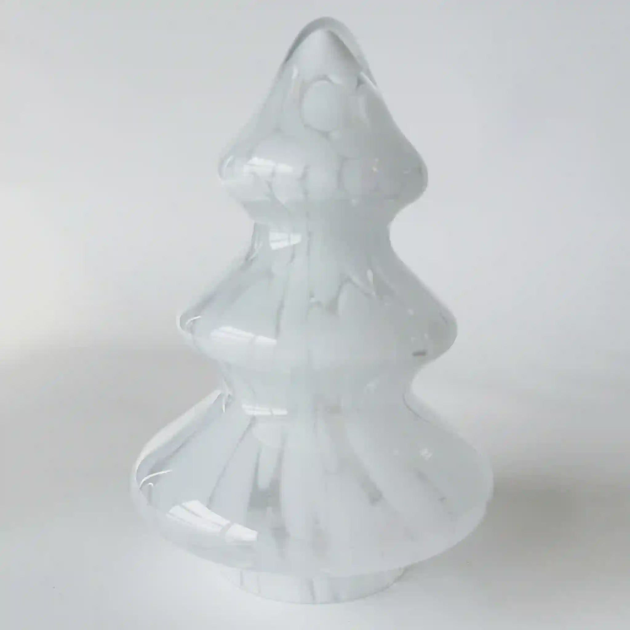 White glass Christmas tree ornament on a light gray background