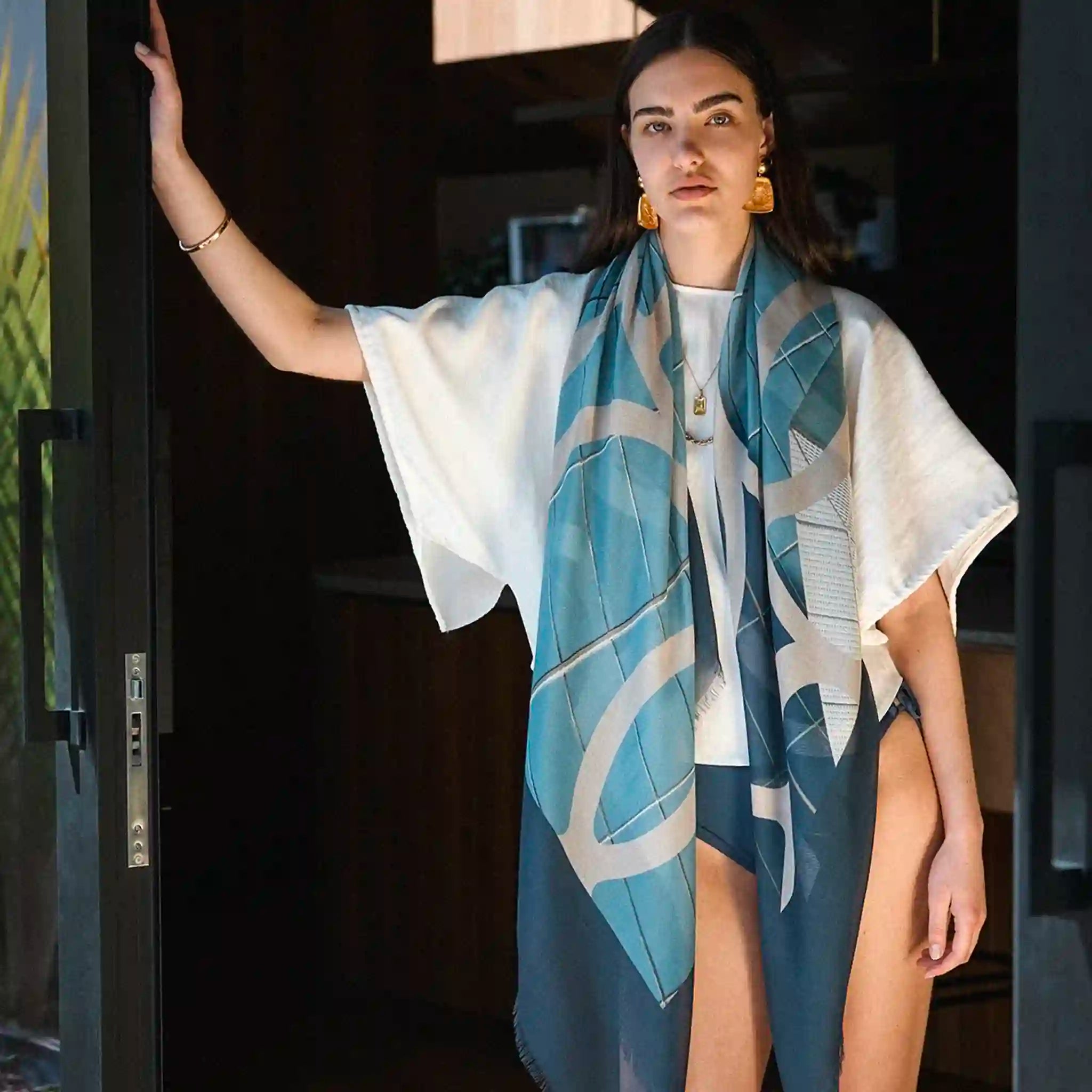 Woman wearing a blue and white patterned scarf in an indoor setting