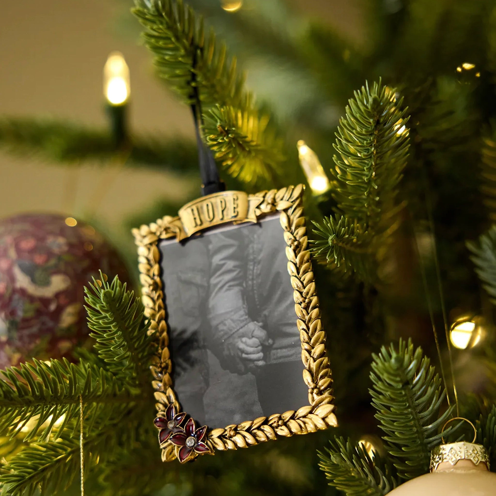 Gold picture frame ornament with 'HOPE' on a Christmas tree