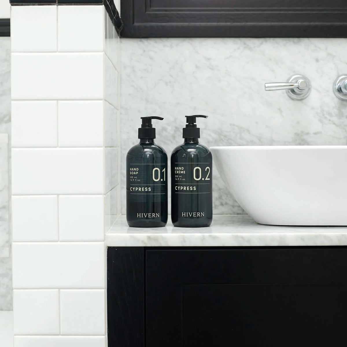 Hivern Cypress Hand Crème and Hand Soap pump bottles on a marble bathroom vanity