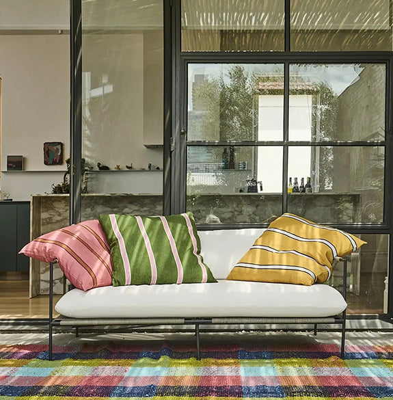 White sofa with colorful striped cushions in a modern living room.