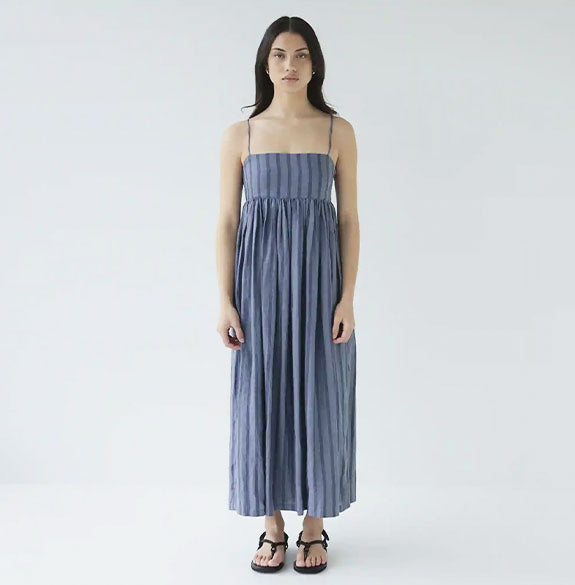 Woman wearing a blue striped dress on a white background