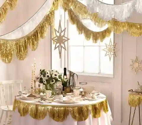 Decorated table with gold tinsel and star decorations in a room.