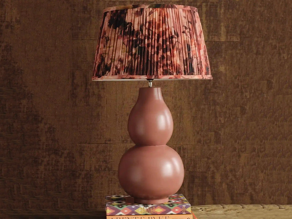 Pink lamp with a patterned shade on a textured surface
