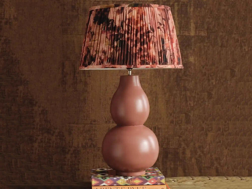 Pink lamp with a patterned shade on a textured surface