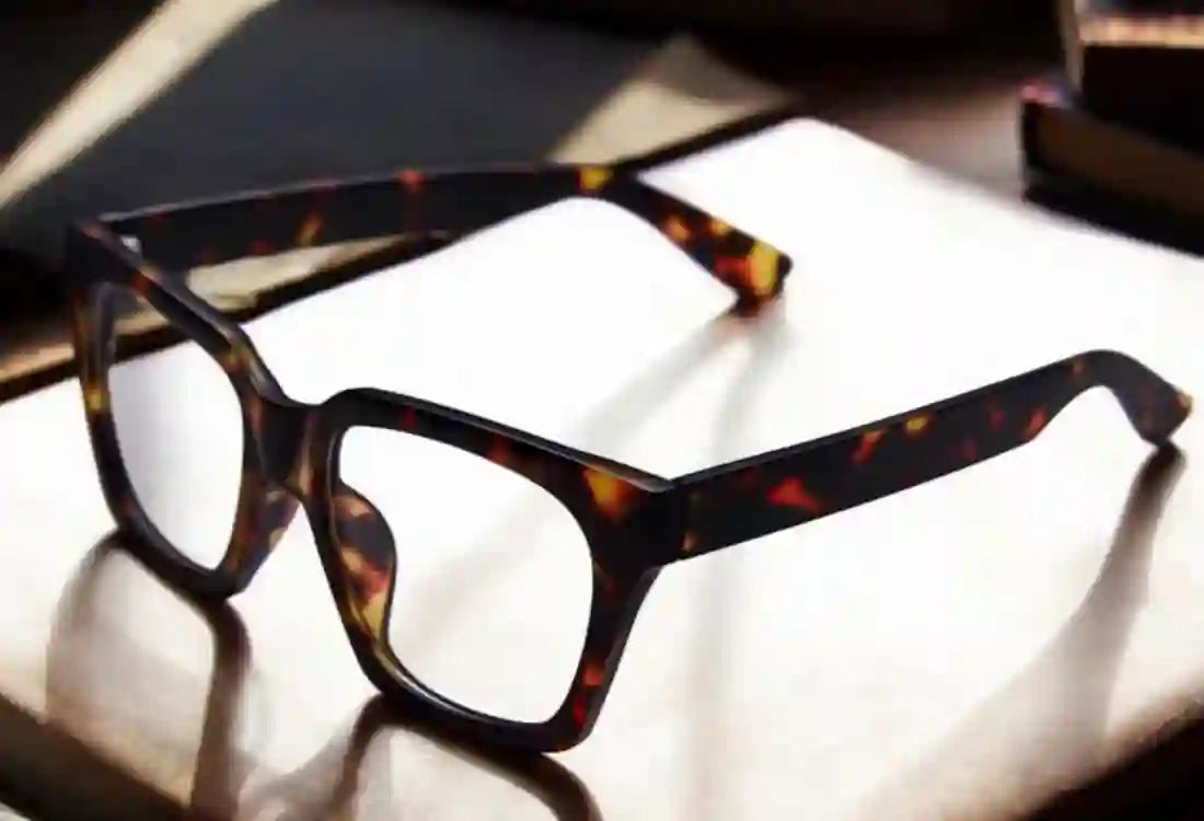 Tortoiseshell glasses on a reflective surface