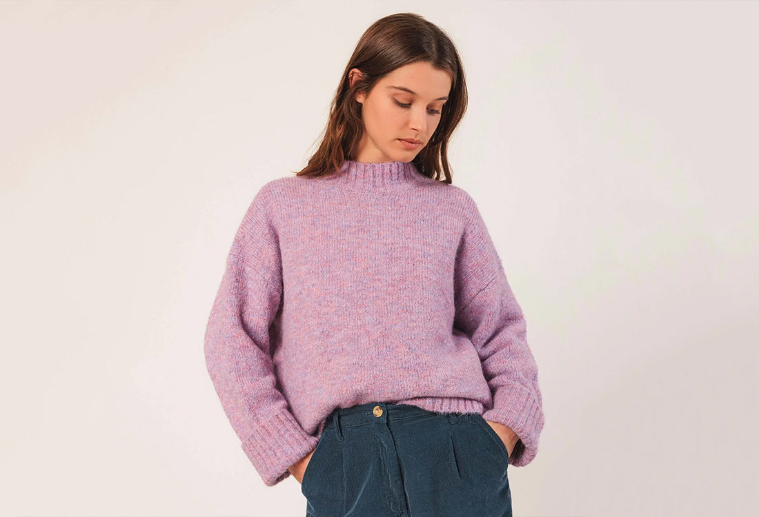 Person wearing a purple sweater against a plain background