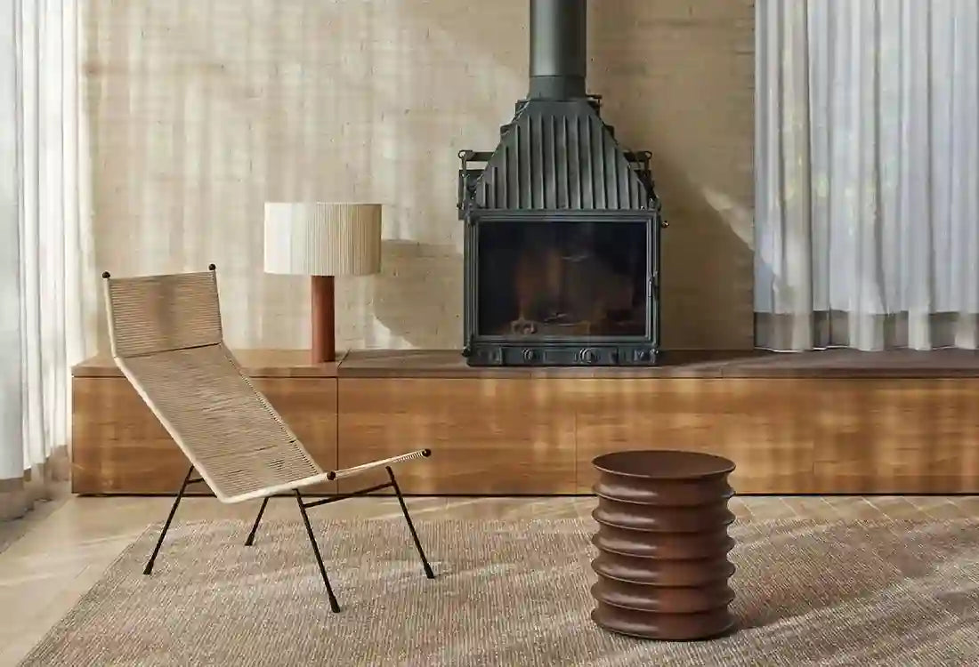 Modern living room with a fireplace, chair, and side table.