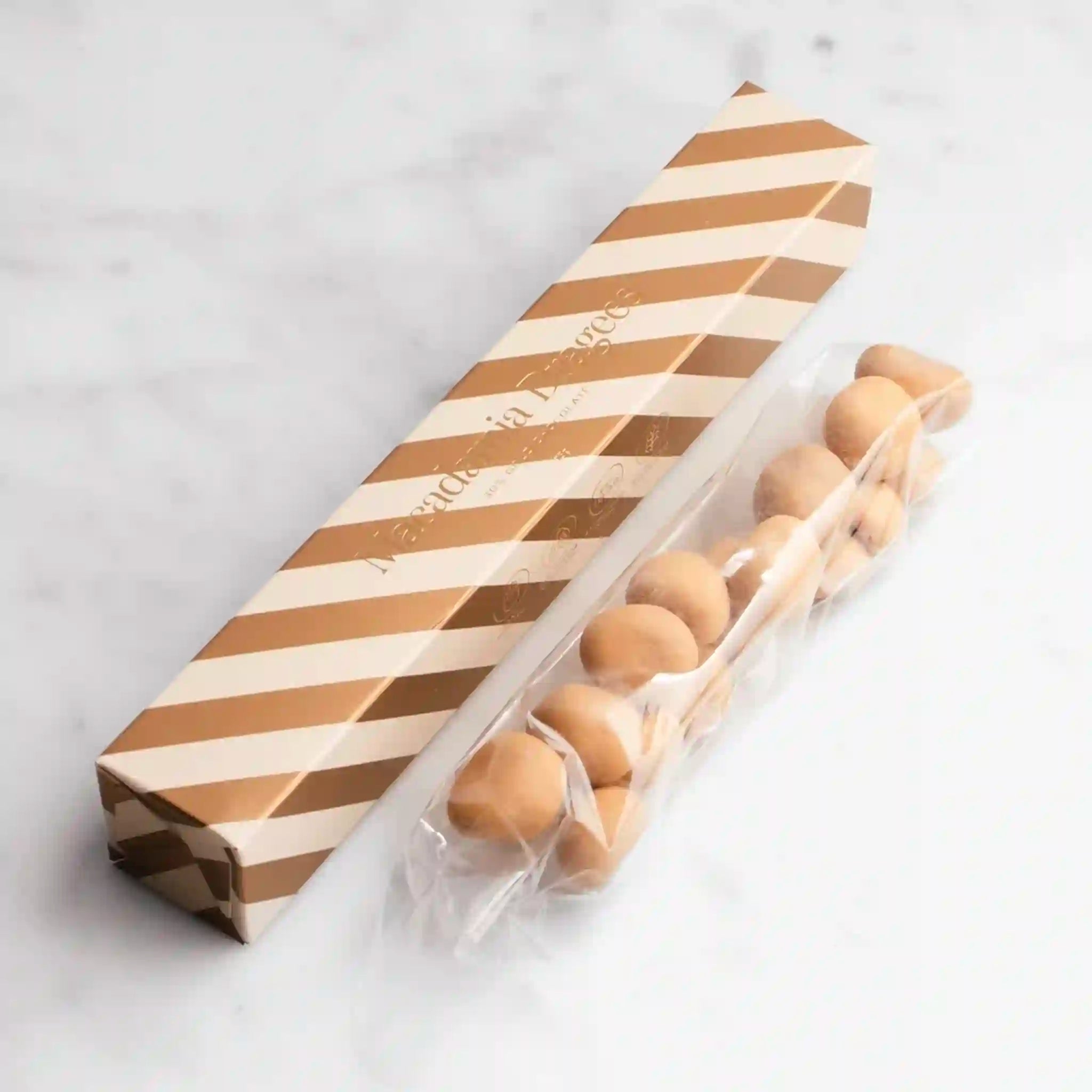 Packaged chocolate balls with a striped paper sleeve on a white background