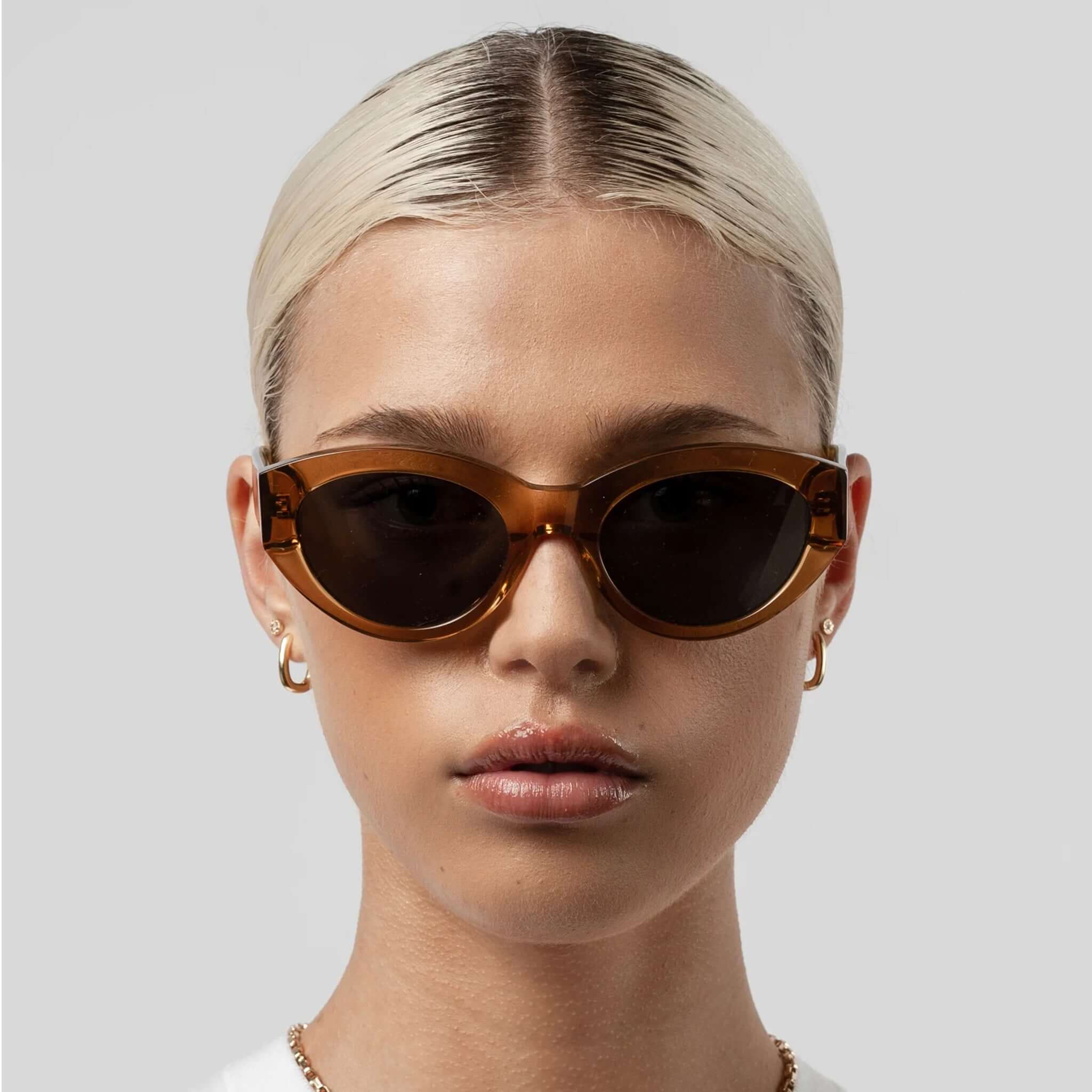 Alt Tag: Isle of Eden Sunglasses - Felina Cognac worn on model, cognac oval lenses, elegant shallow frame with mid-width arms