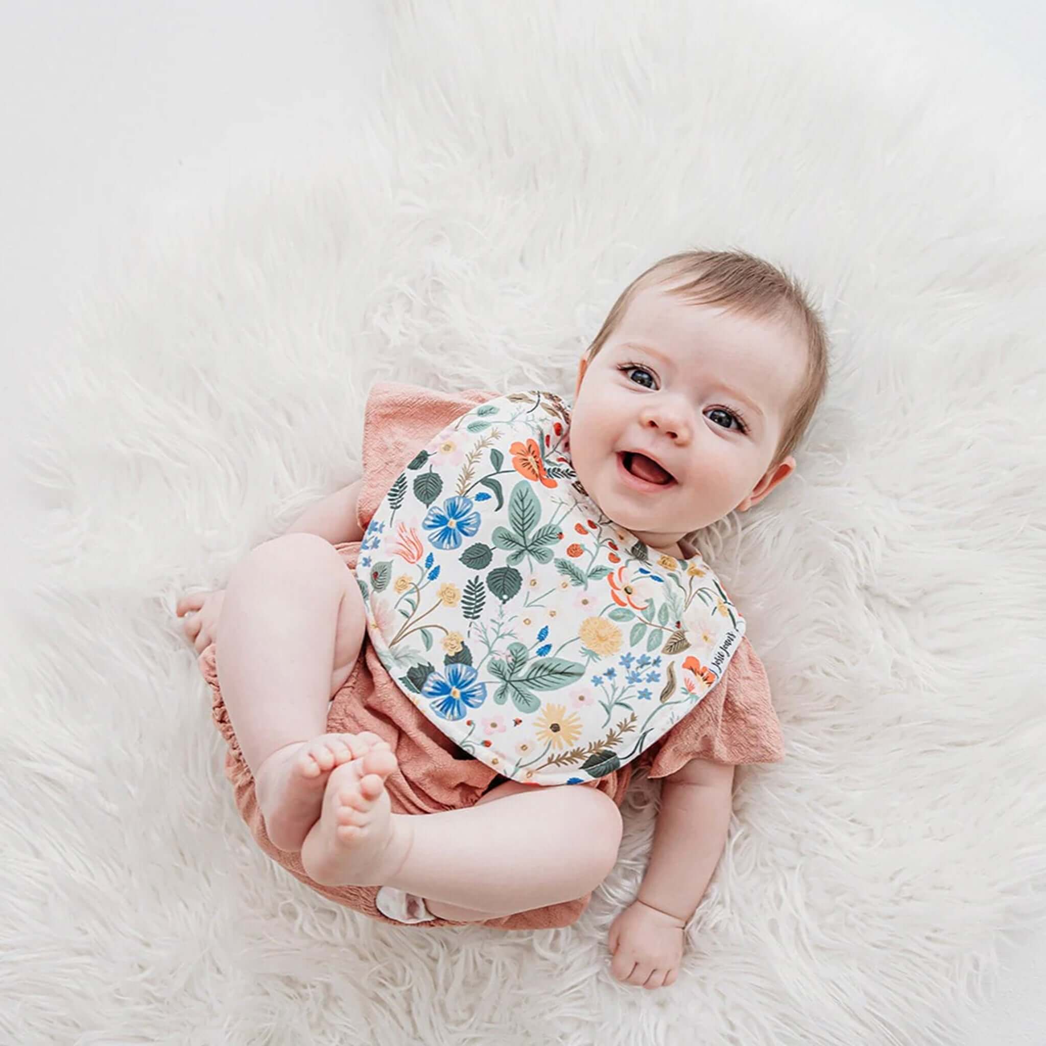 Alt Tag: Josie Joan's Linen Bib - Sybil floral baby bib with snap buttons and micro fleece backing on smiling baby