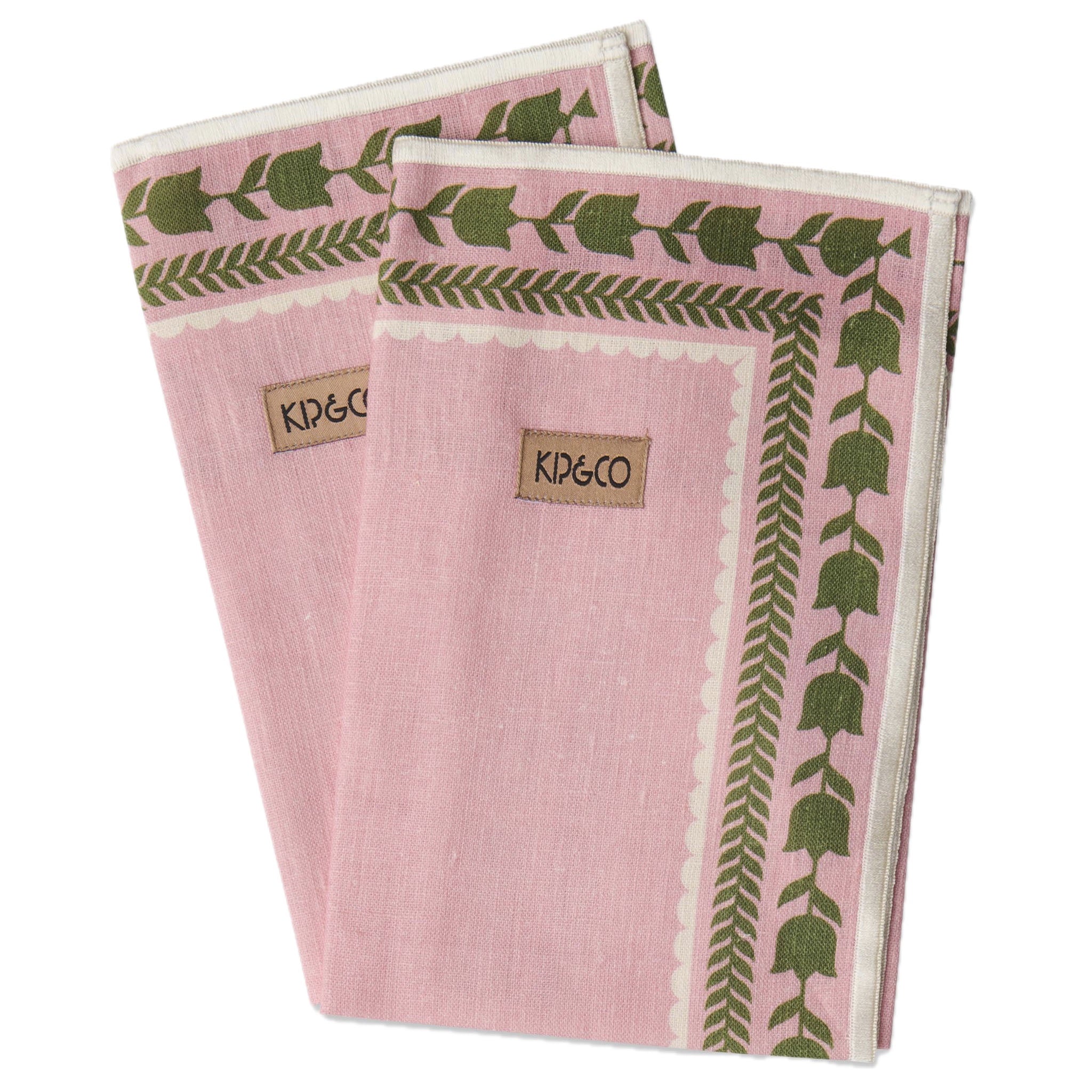 Two pink napkins with green leaf patterns and Kip & Co branding on a white background