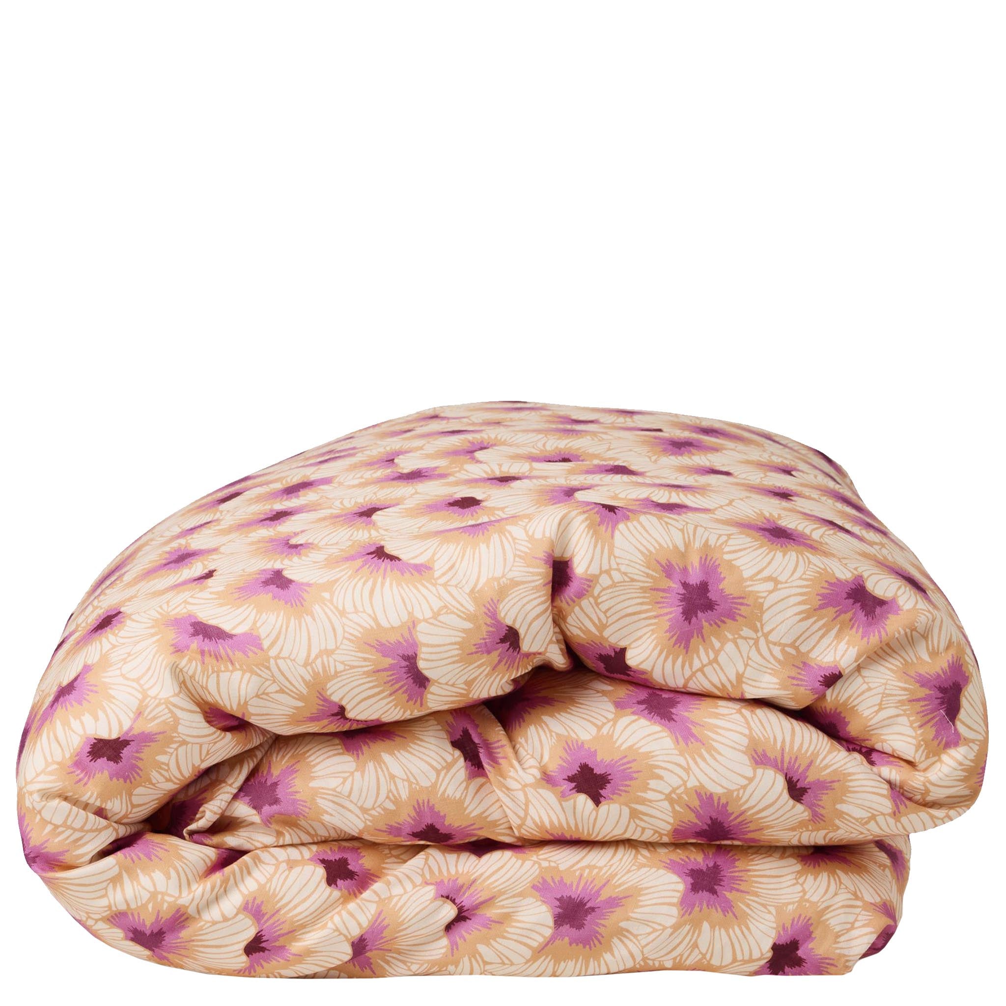 Folded floral quilt with pink and beige pattern on a white background