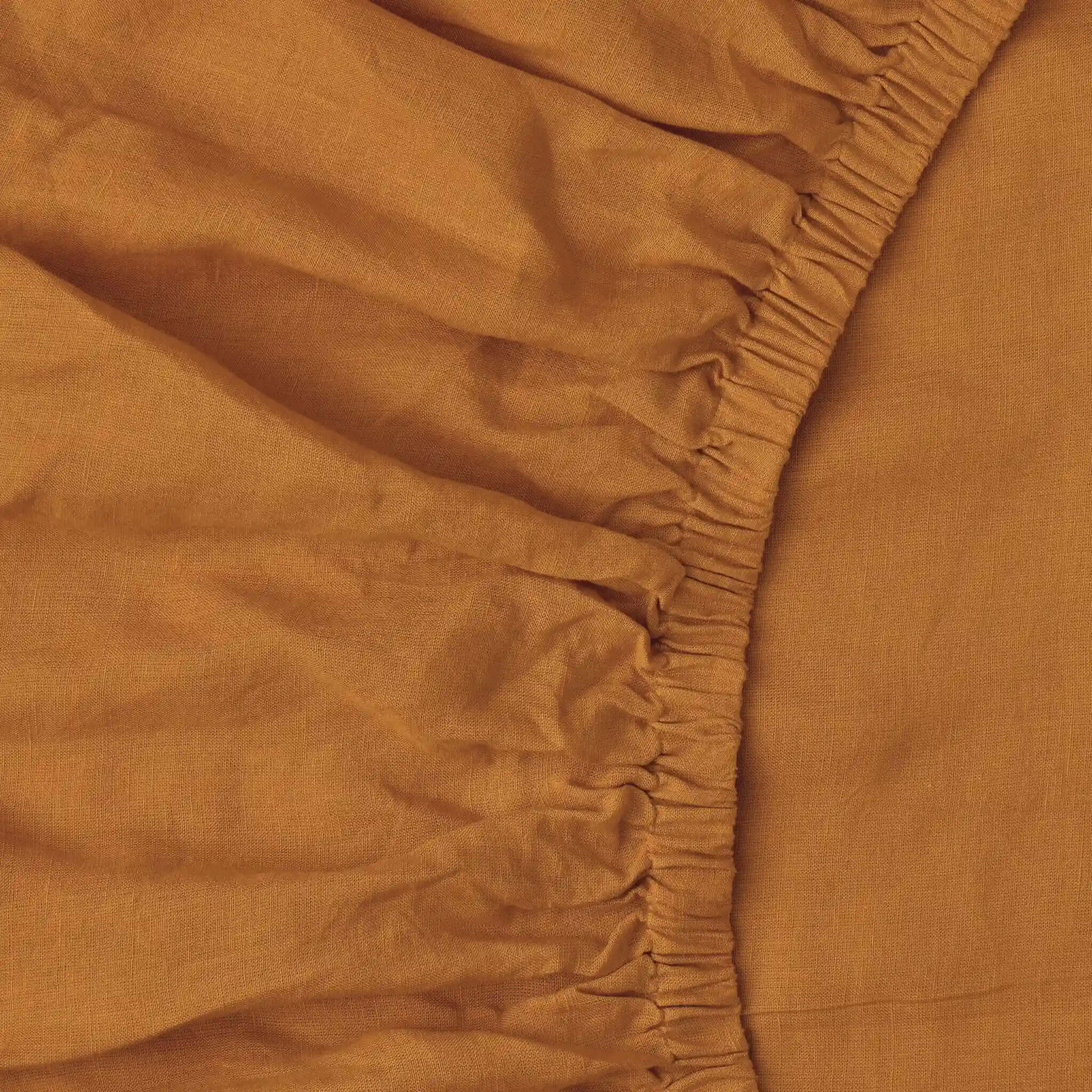 Close-up of a brown fitted sheet with a subtle texture.