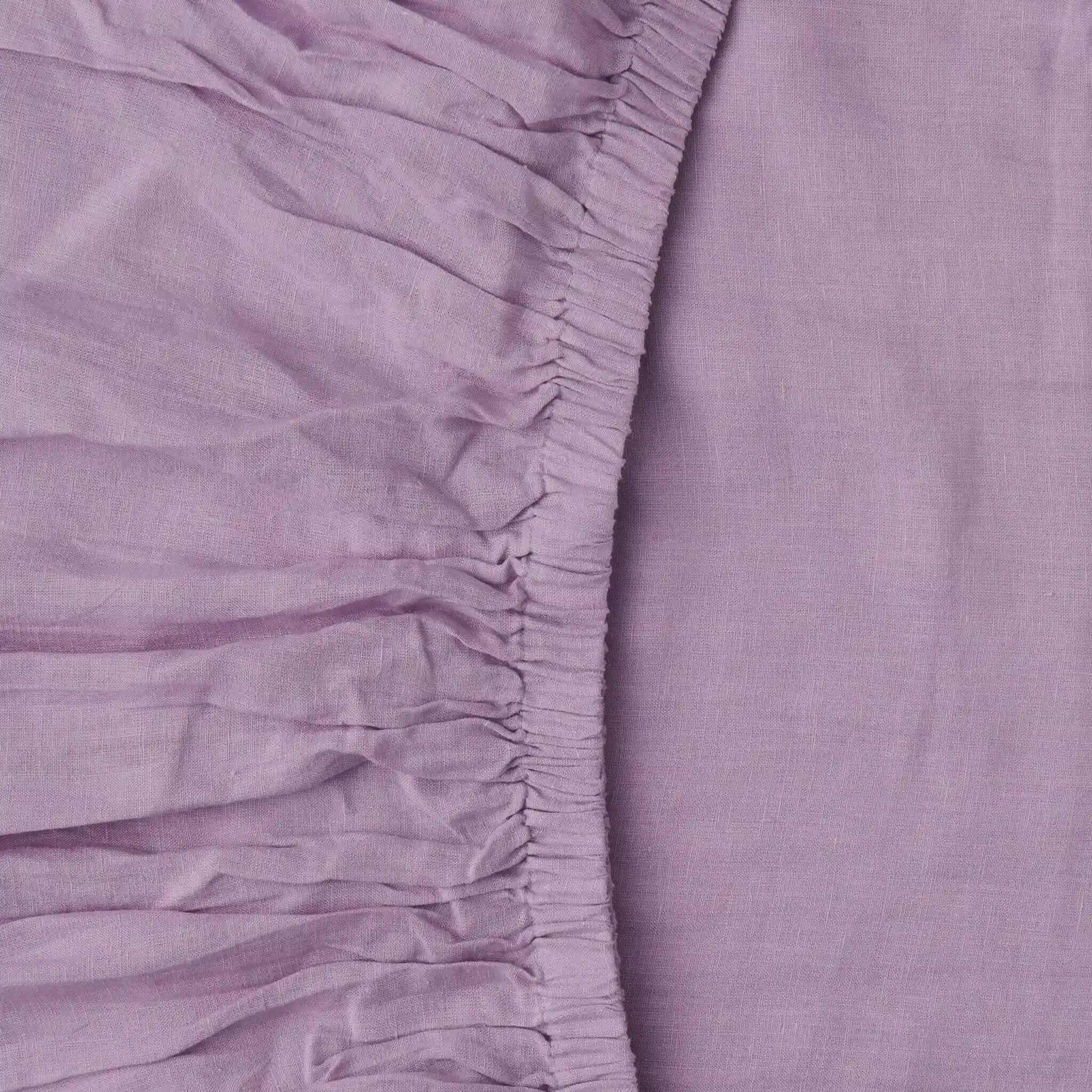 Close-up of a purple fitted sheet with a textured finish