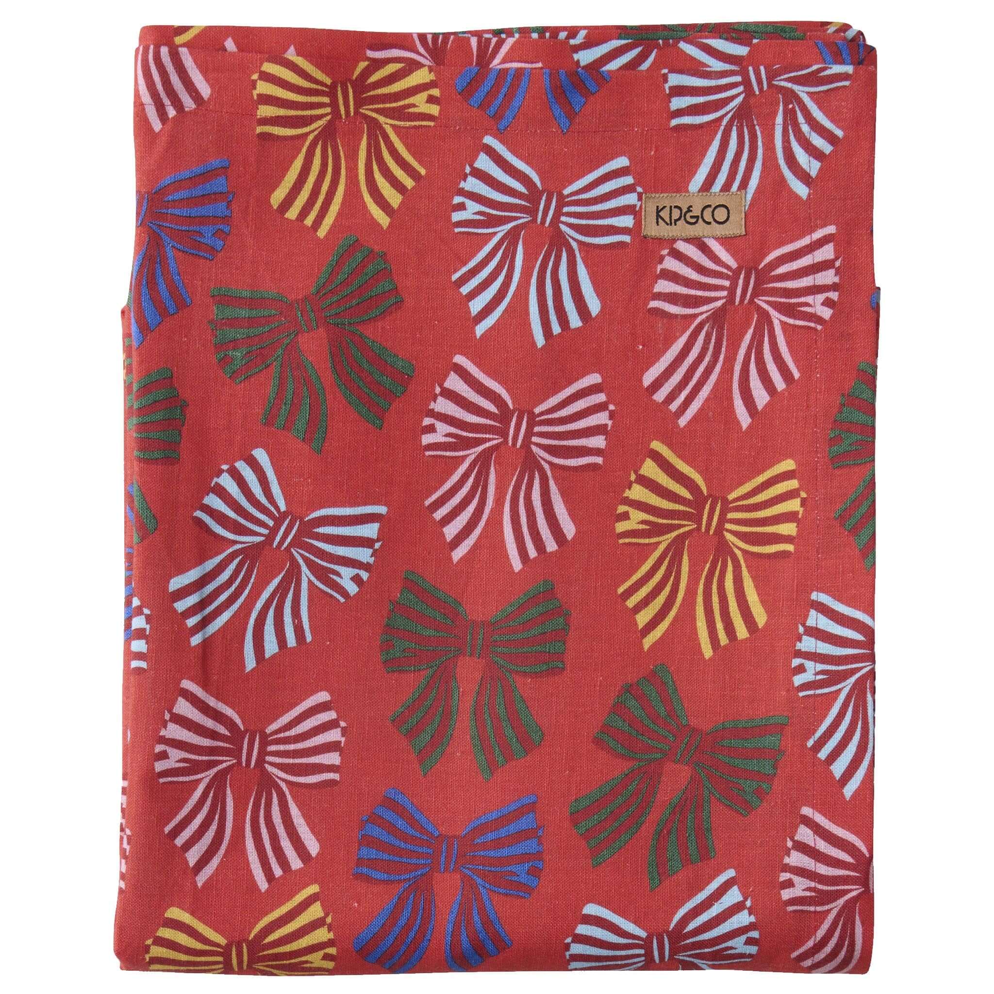 Red tablecloth with colorful bow pattern and Kip & Co branding