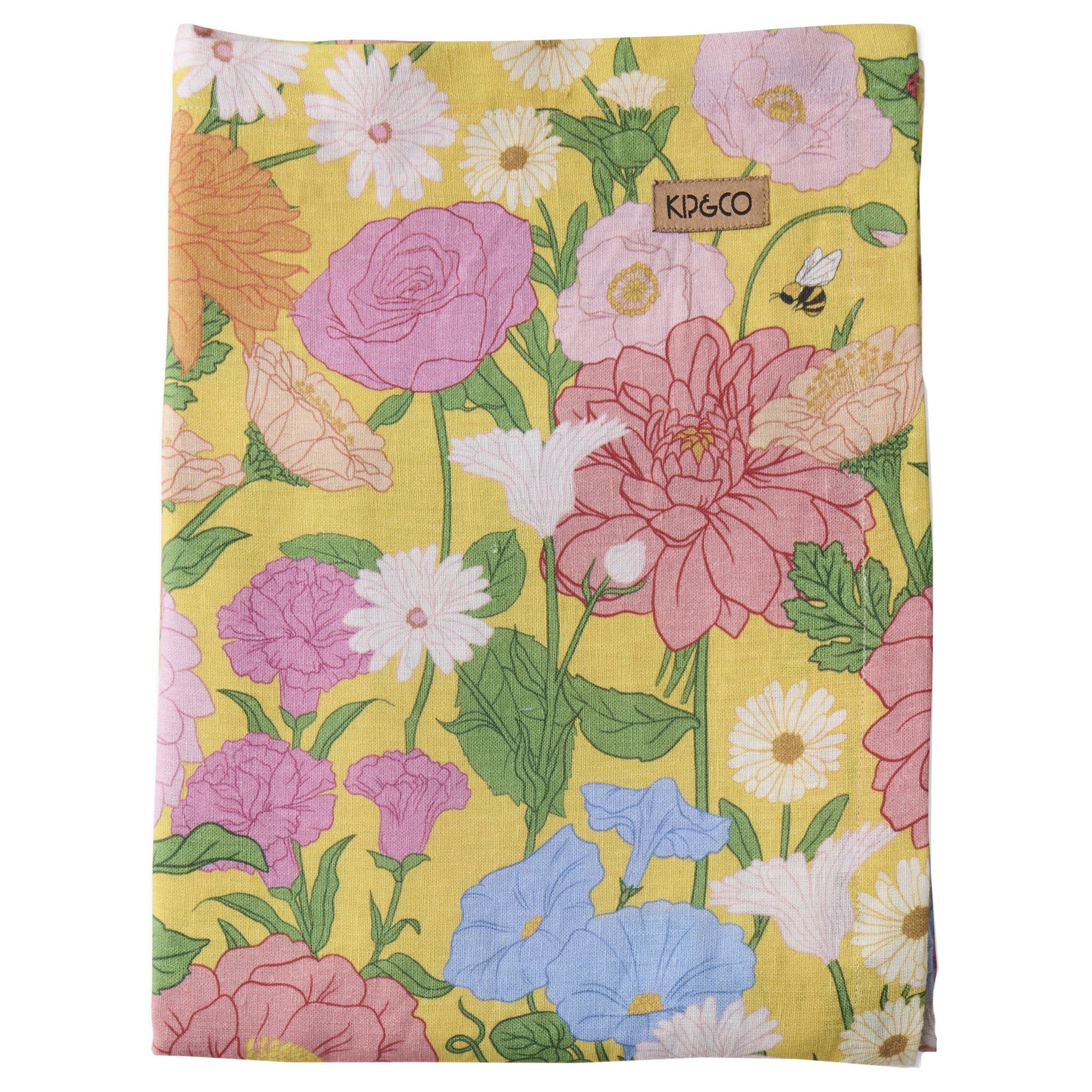 Floral patterned tablecloth with 'Kip & Co' branding on a yellow background