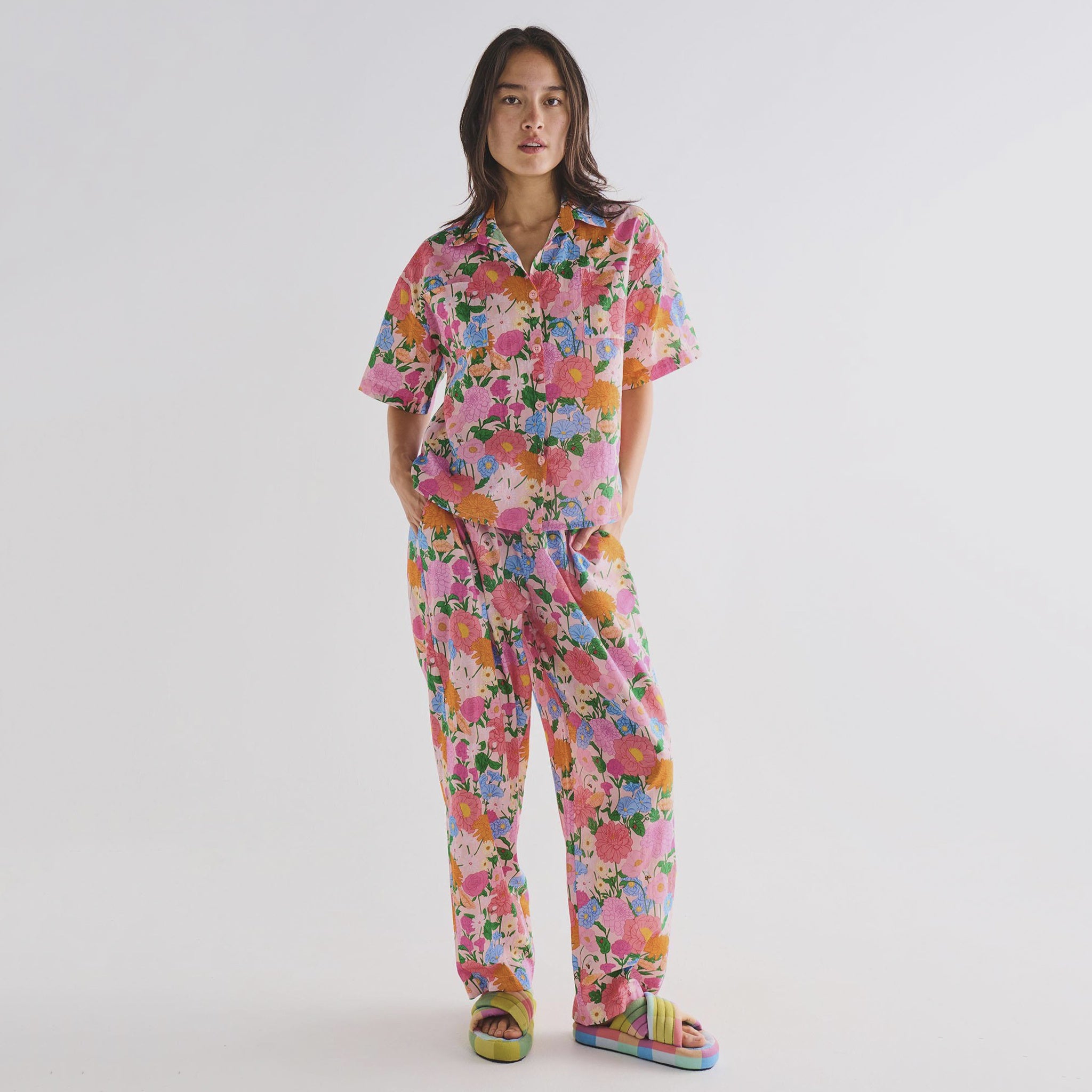Person wearing a colorful floral pyjamas on a plain background