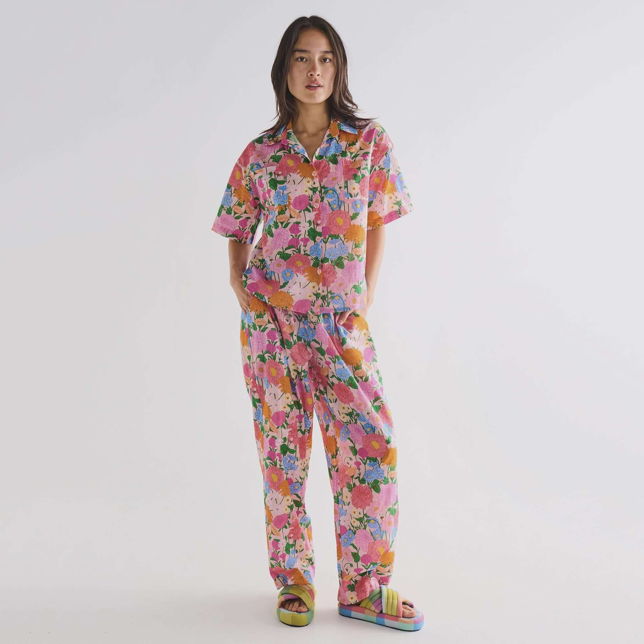 Person wearing a colorful floral pyjamas on a plain background
