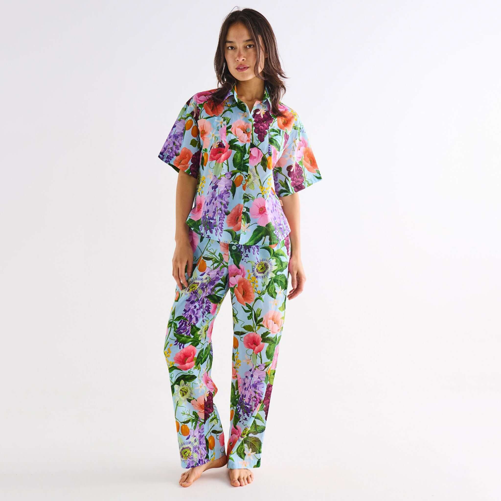 Woman wearing a colorful floral pajama set on a white background