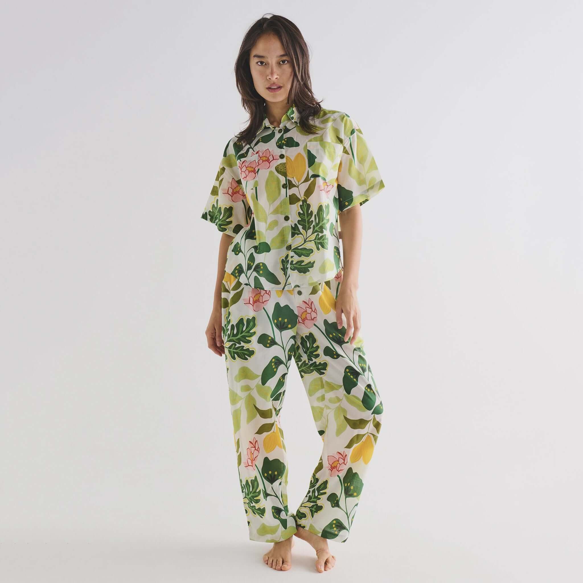 Alt Tag: Kip & Co Organic Cotton Short Sleeve Shirt & Pants Pyjama Set - Wander on model, button-up short sleeve shirt and pants in floral print