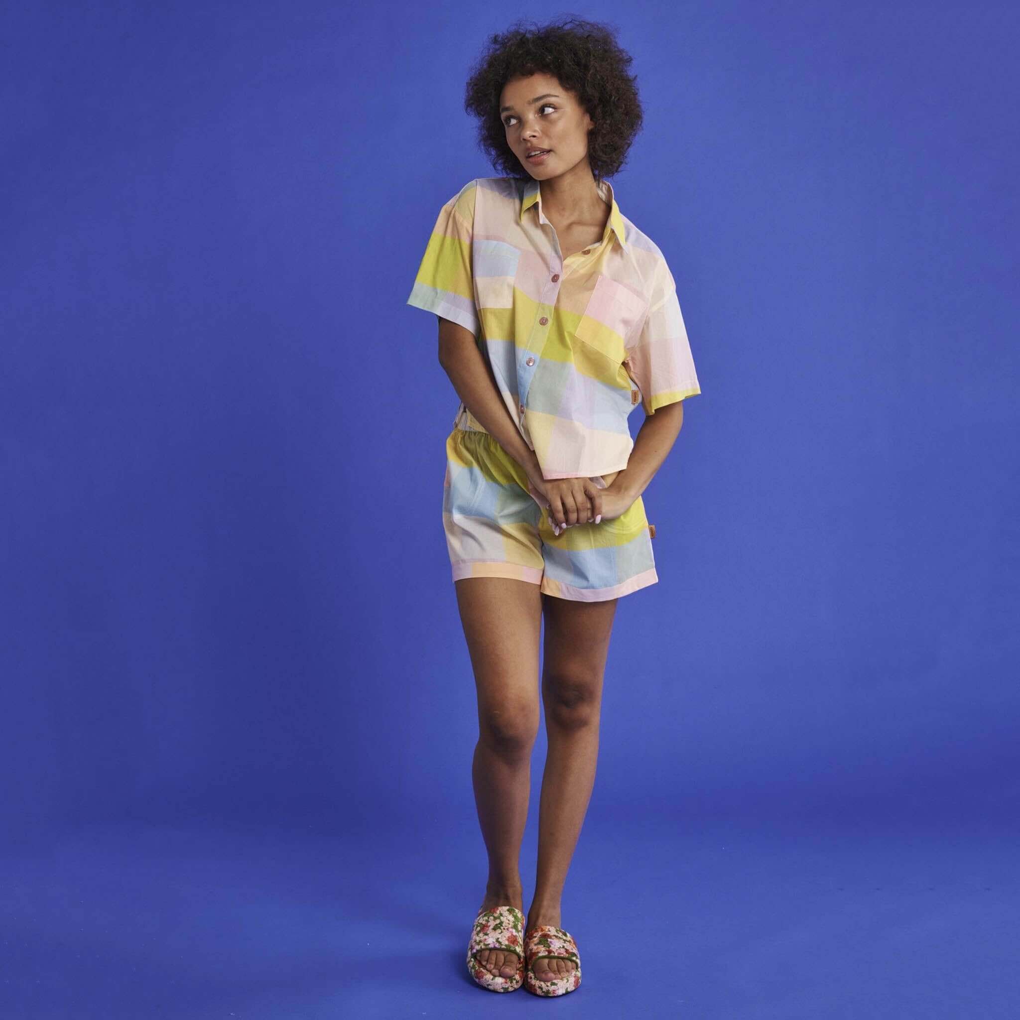 Alt Tag: Kip & Co Organic Cotton Short Sleeve Shirt & Shorts Pyjama Set - Corfu Tartan model wearing short-sleeve shirt and shorts set