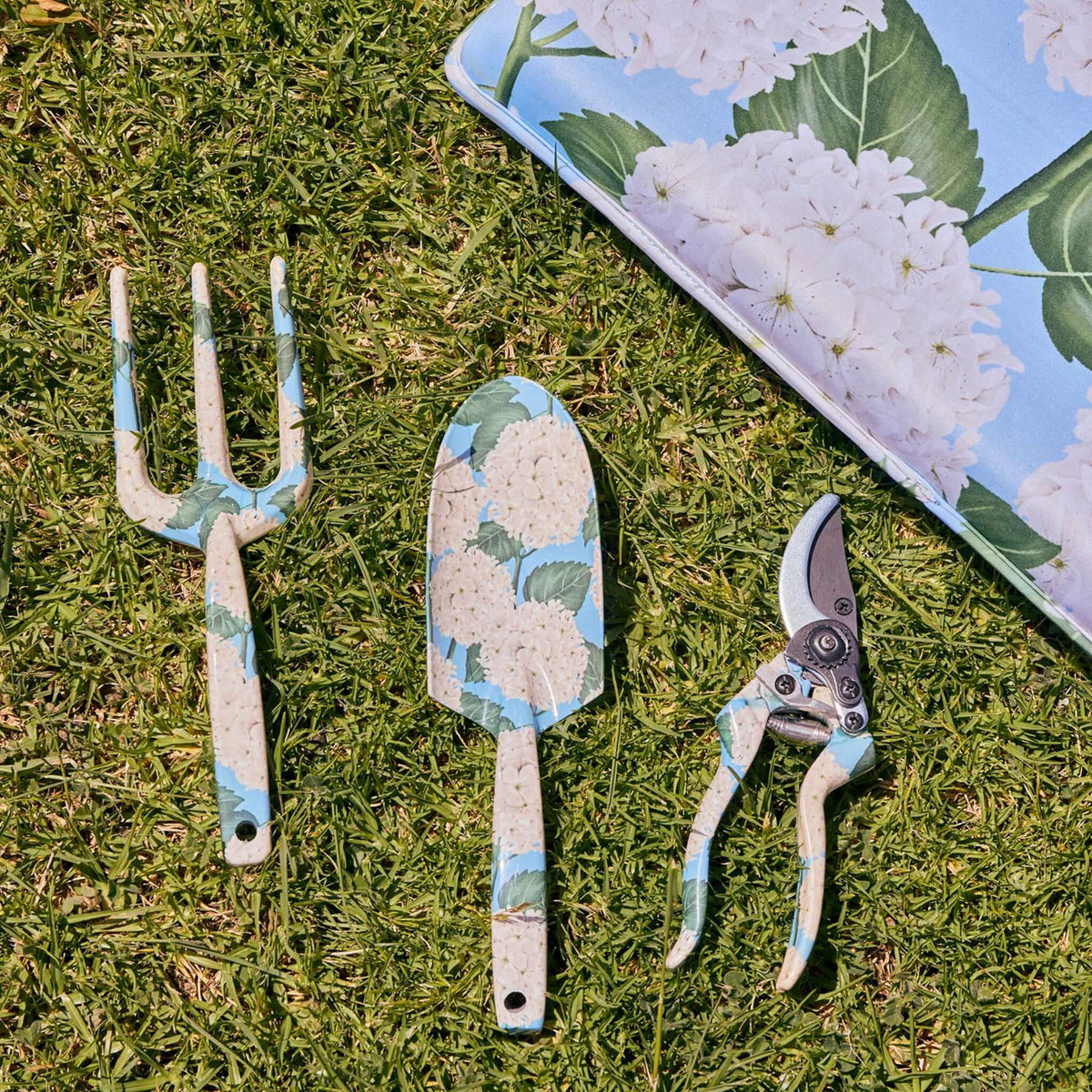 Kip & Co Garden Tools & Gloves Set - Hydrangea Blue featuring fork, trowel, and pruners on grass