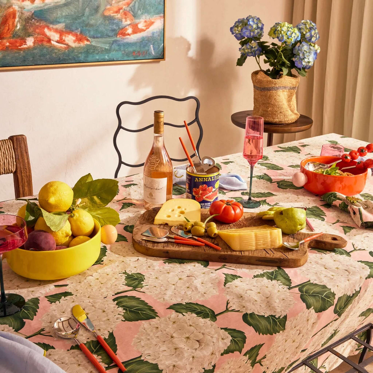 Kip & Co Linen & Cotton Tablecloth - Hydrangea Pink set on a dining table with food and drinks.