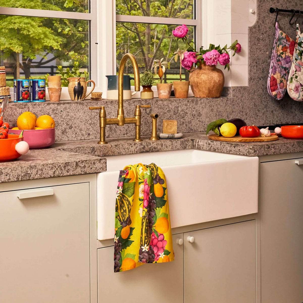 Kip & Co Linen & Cotton Tea Towel - Garden of Plenty hanging by the sink in a vibrant kitchen.