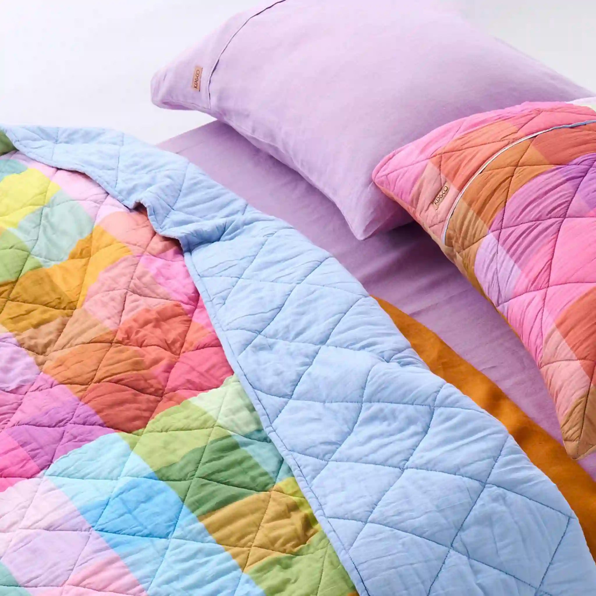 Colorful quilt with pastel pillows on a bed
