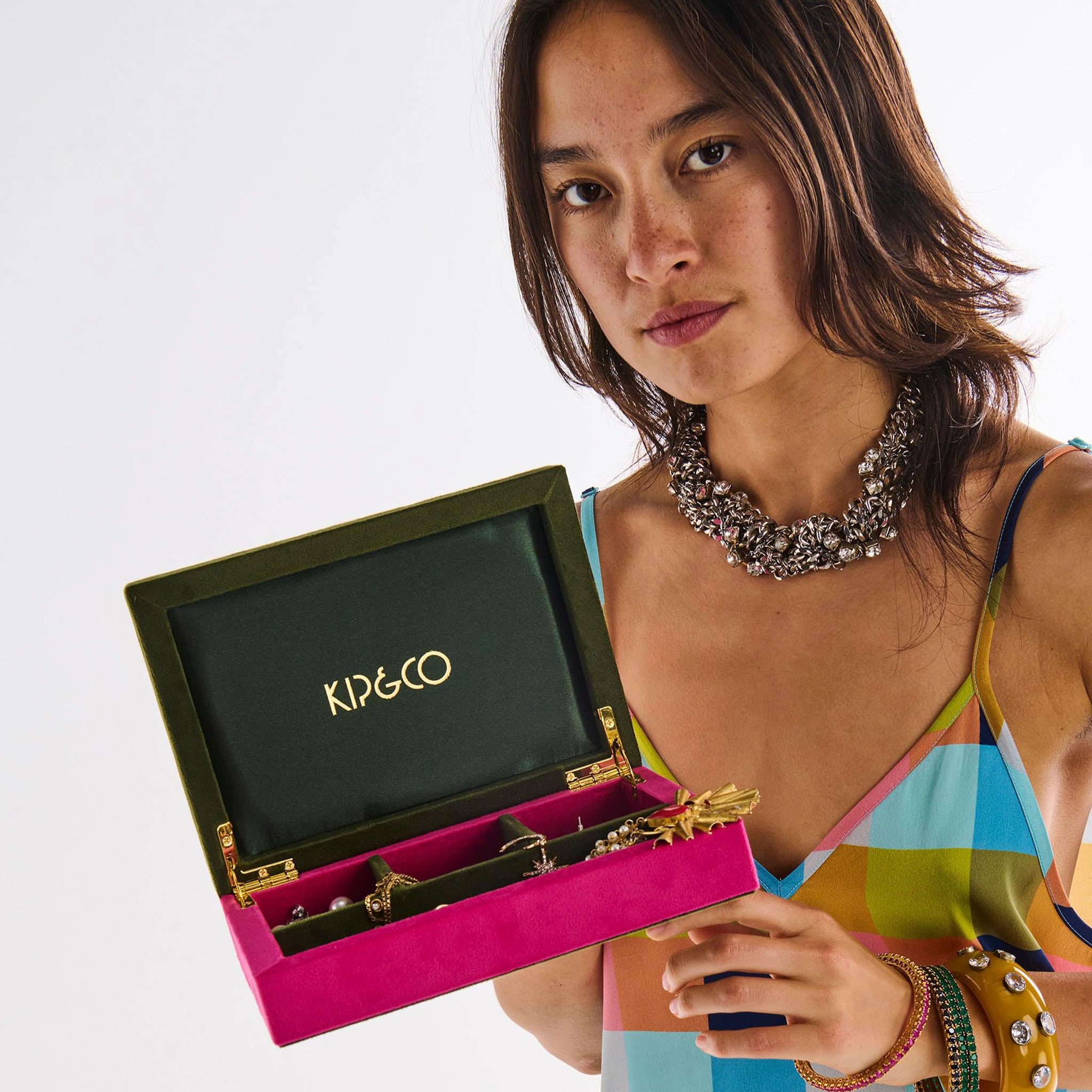 Woman holding a pink and green jewelry box with 'Kip & Co' branding