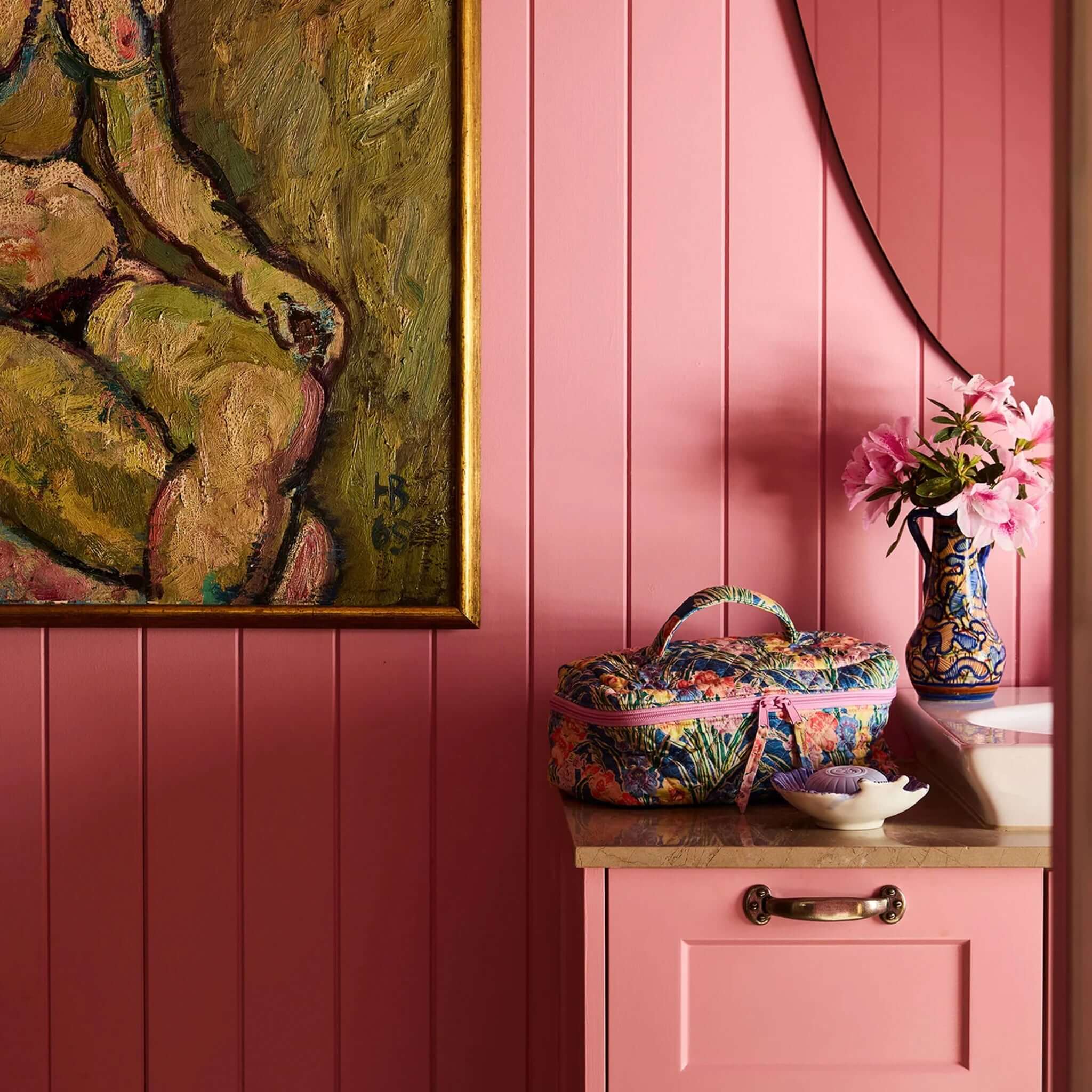 Kip & Co x Anna Spiro Quilted Toiletry Case - Gladiolus displayed on a pink cabinet next to flowers and artwork.