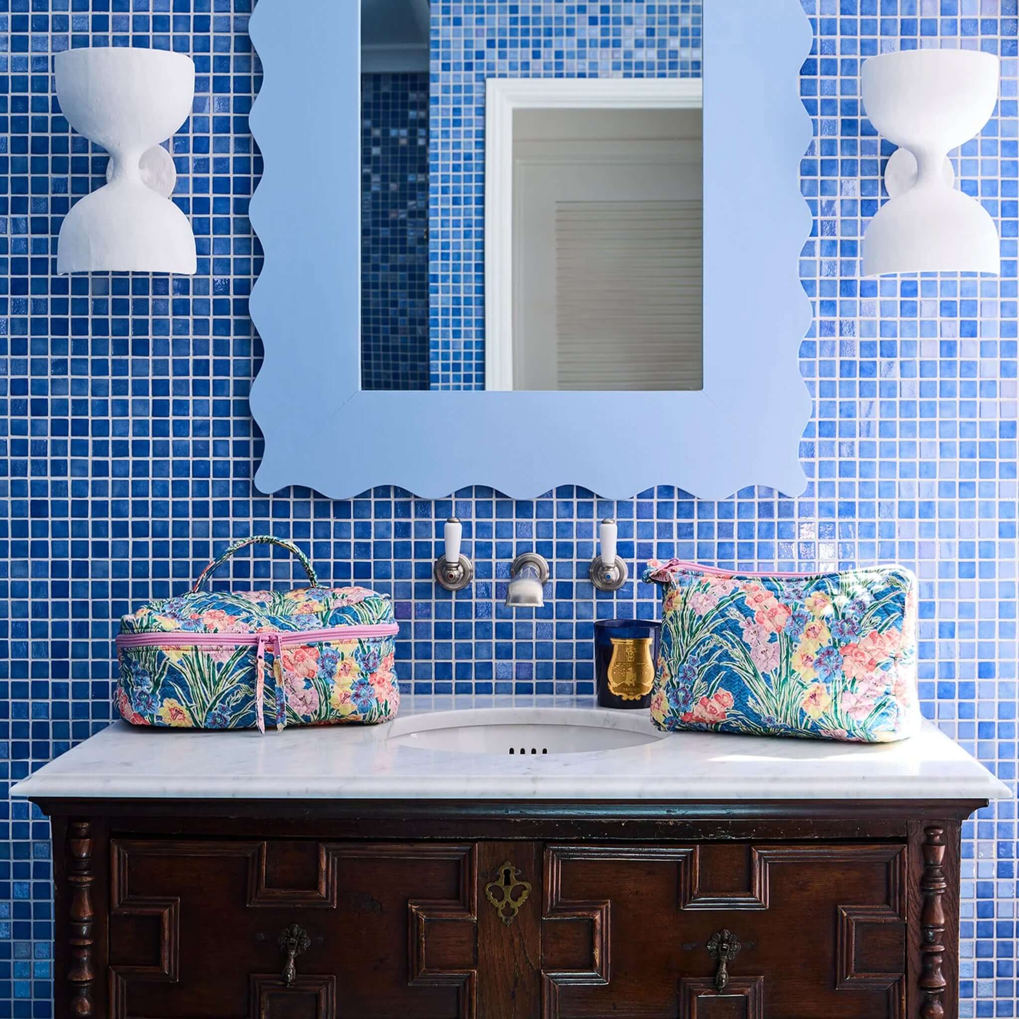 Kip & Co x Anna Spiro Quilted Toiletry Purse - Gladiolus on a bathroom counter with blue mosaic tiles.