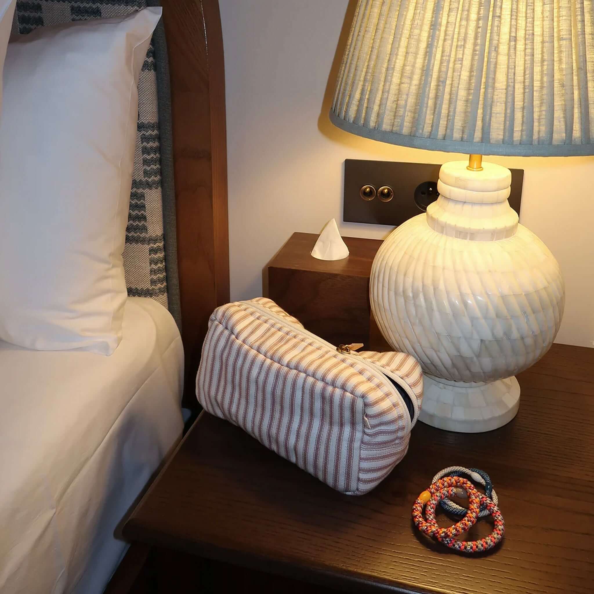 Kknekki Hair Tie - Mix Nougat Neon Pink next to a stylish lamp on a bedside table in a cozy bedroom setting.