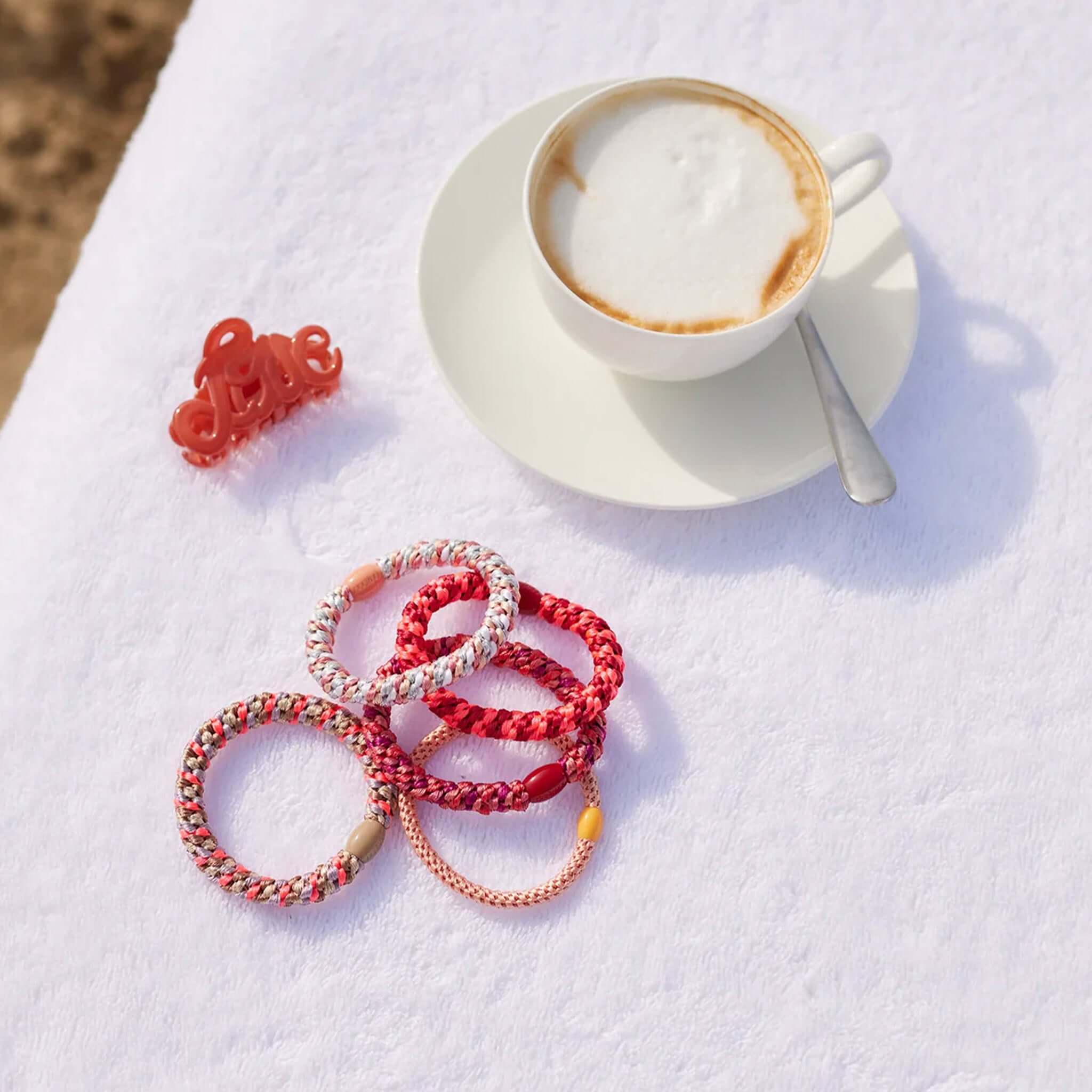 Kknekki Hair Tie - Red Neon Pink Stripe woven hair ties flatlay with coffee cup, waterproof no-damage hold, recycled bead